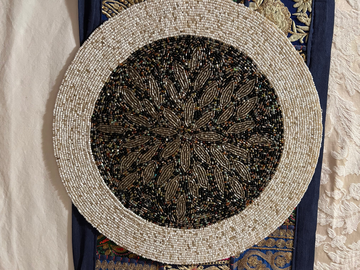 Handcrafted beadwork accent placemats and chargers, featuring intricate designs and vibrant colors, adding a touch of elegance and artistry to your table setting.