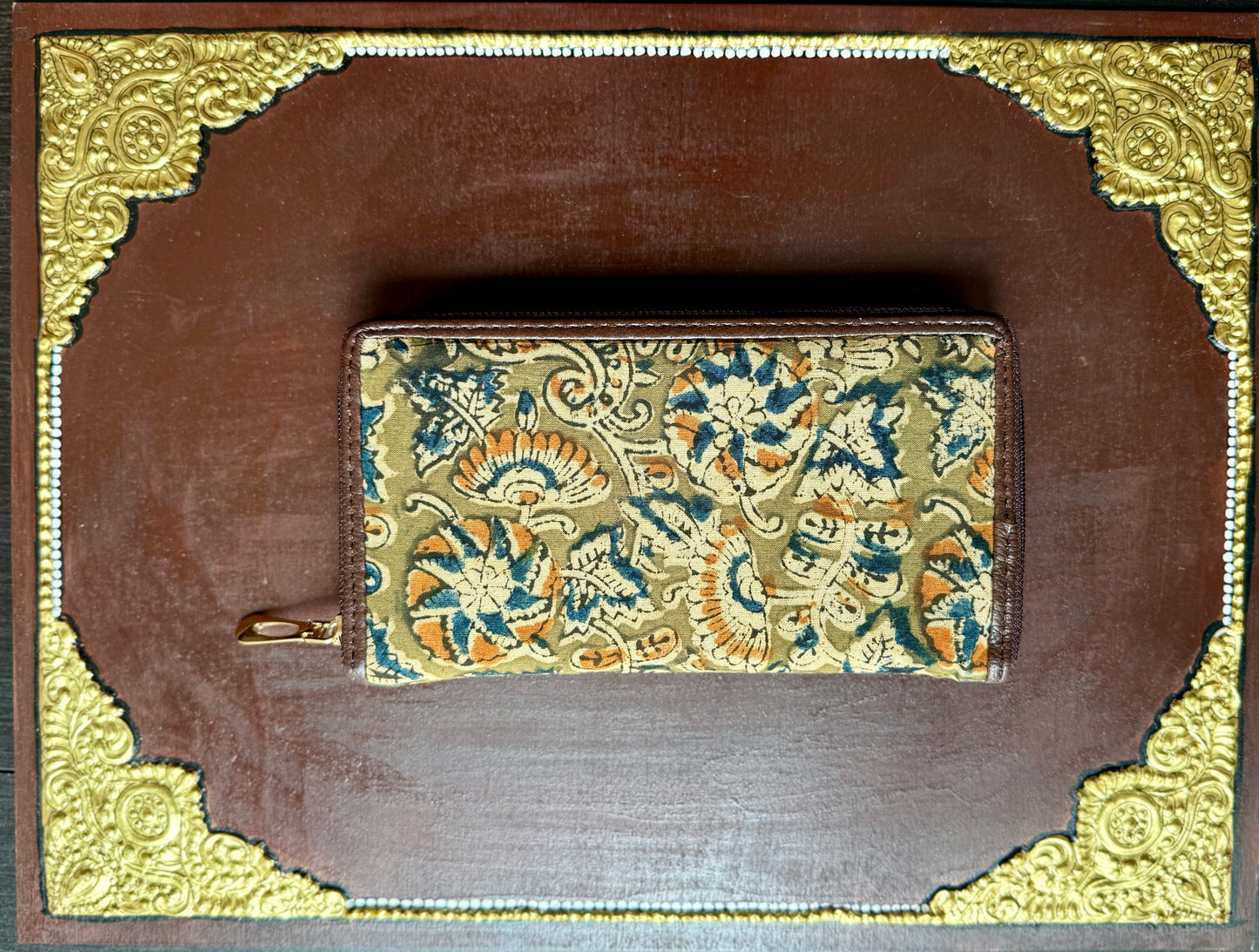 Decorative Ajrakh wallet with floral pattern on a brown background