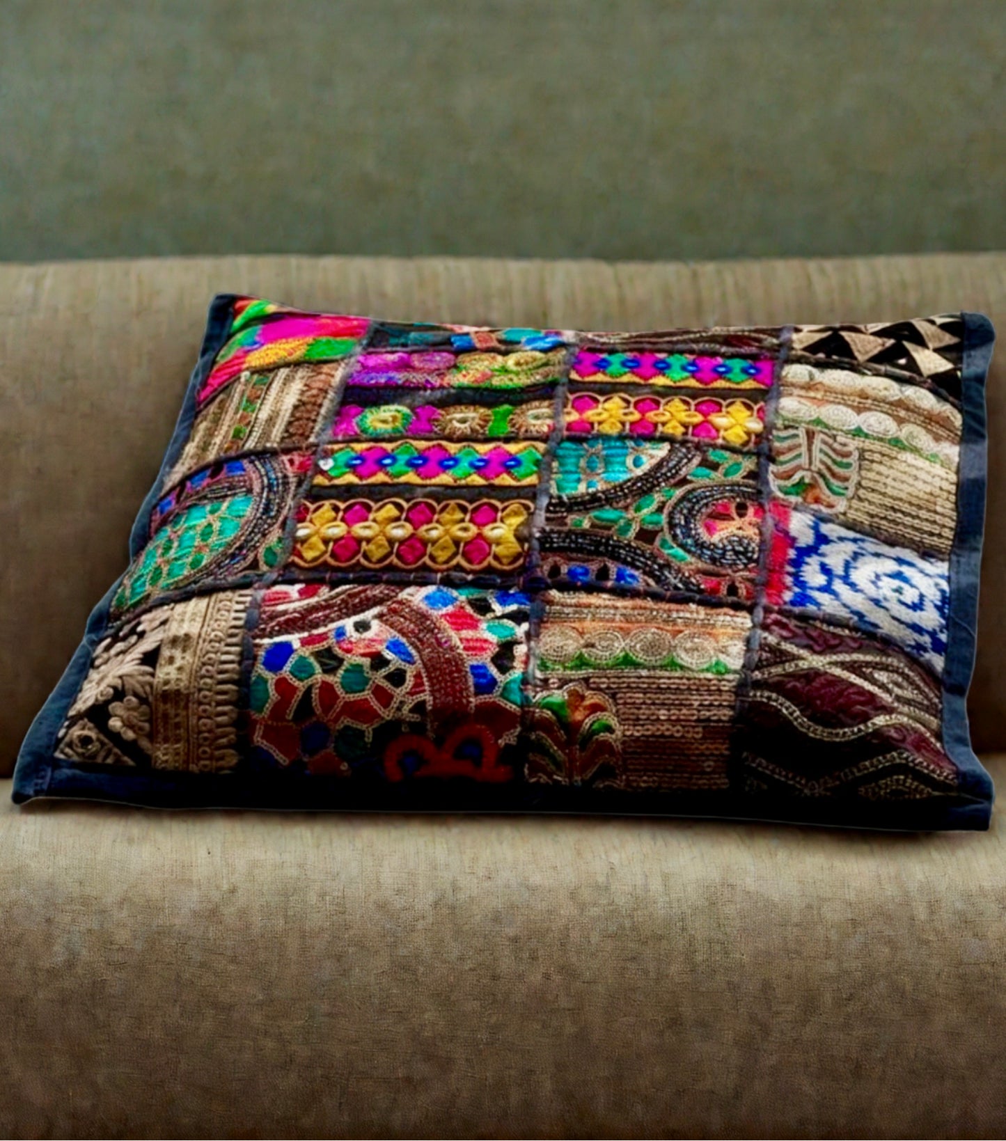 Cushion cover crafted from Khambhadia patchwork, showcasing a collage of vintage fabrics, intricate embroidery, and mirror accents in bold, vibrant colors.