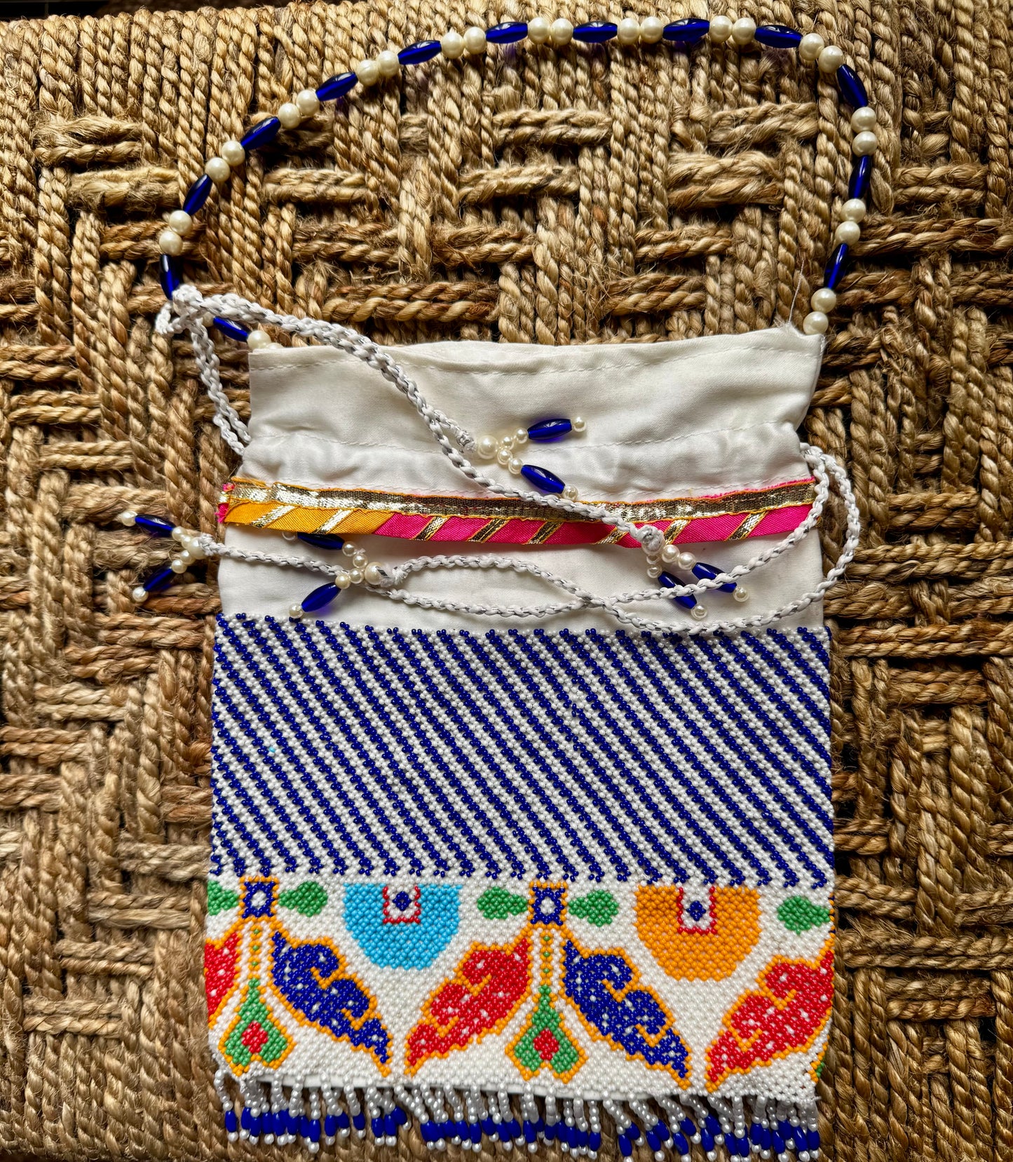 Handmade strung Pearl work pouch/Potlis/batwa with colorful patterns on a woven surface