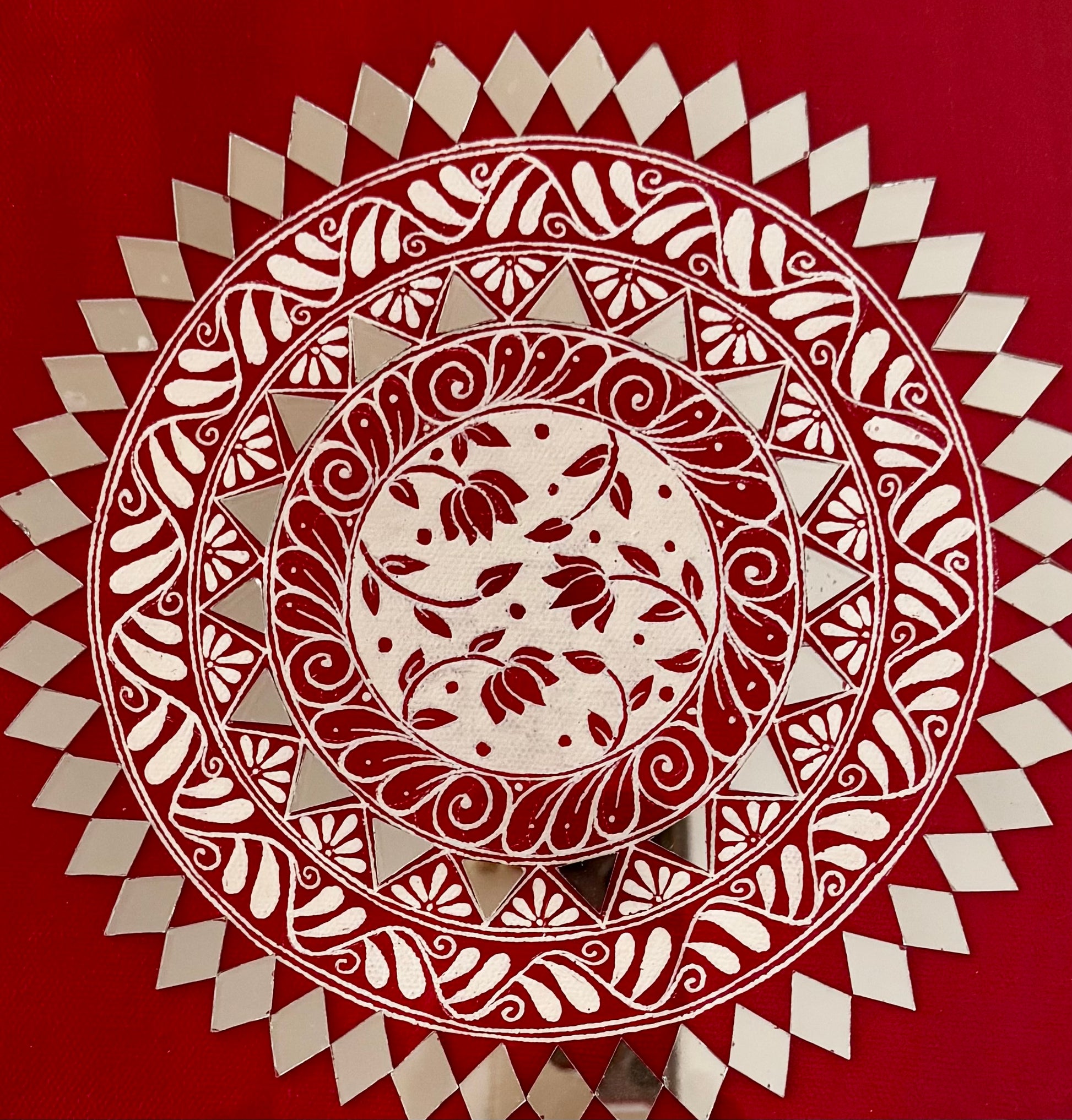 Decorative circular pattern in Aipan Art with red and white colors on a red background