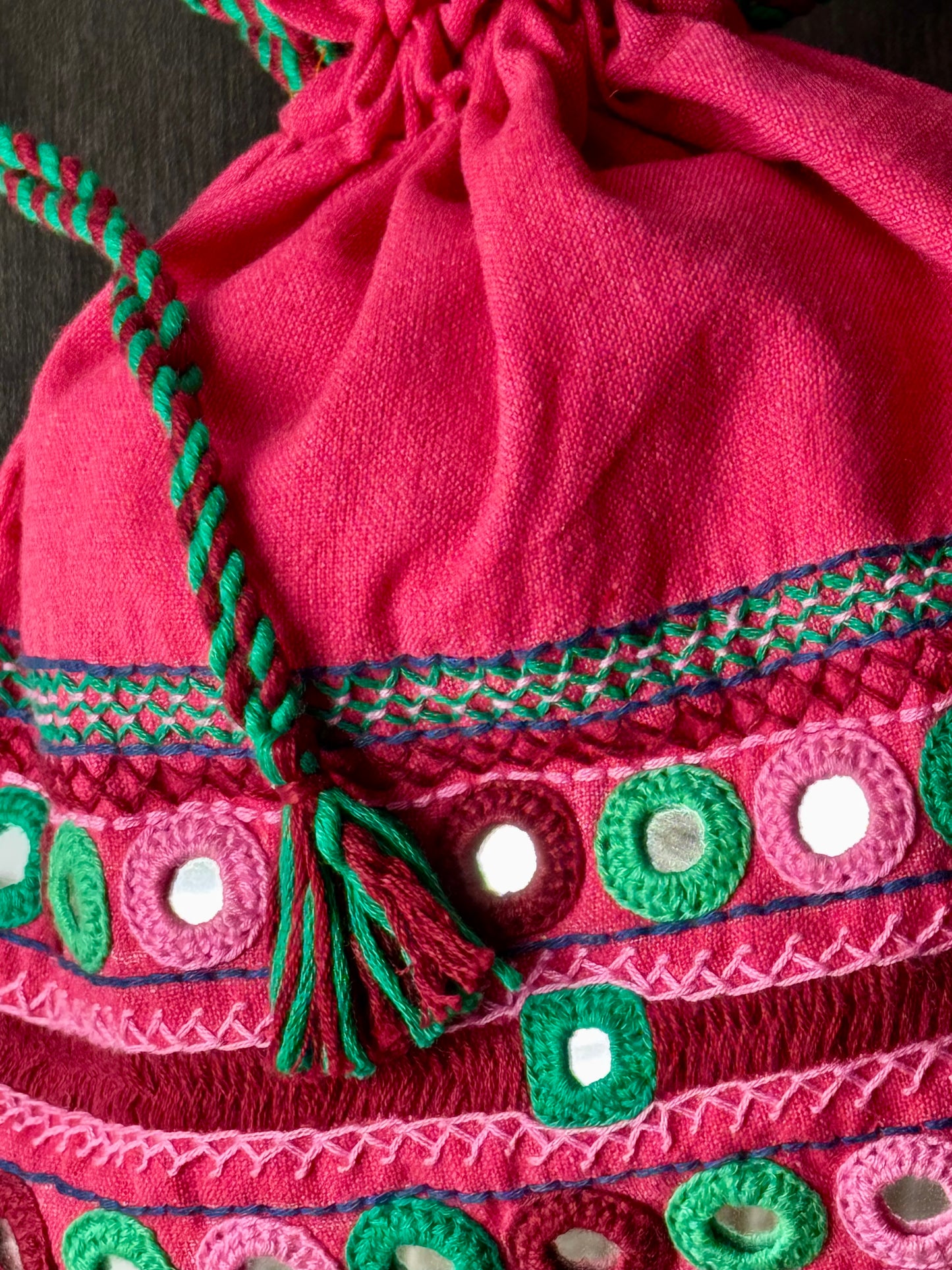 Close up of pink potli bag with intricate Lambani embroidery work