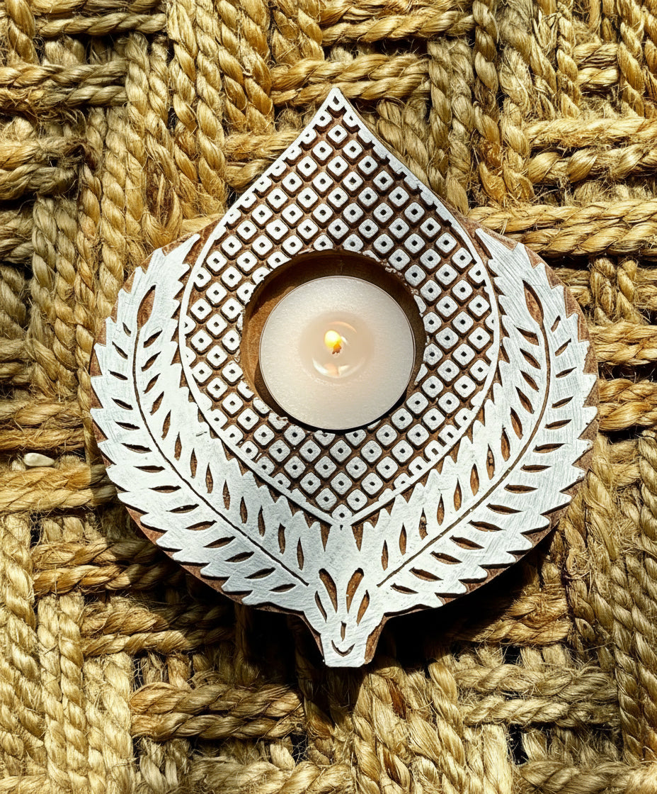 Decorative hand engraved wooden block tea light holder on a textured woven surface
