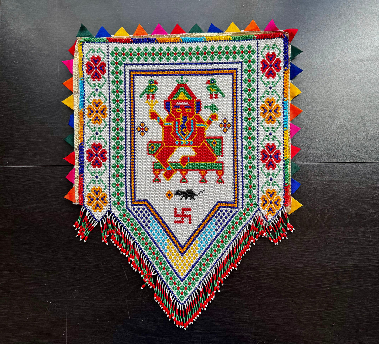 Colorful Ganesh In Motikaam with intricate patterns on a dark surface