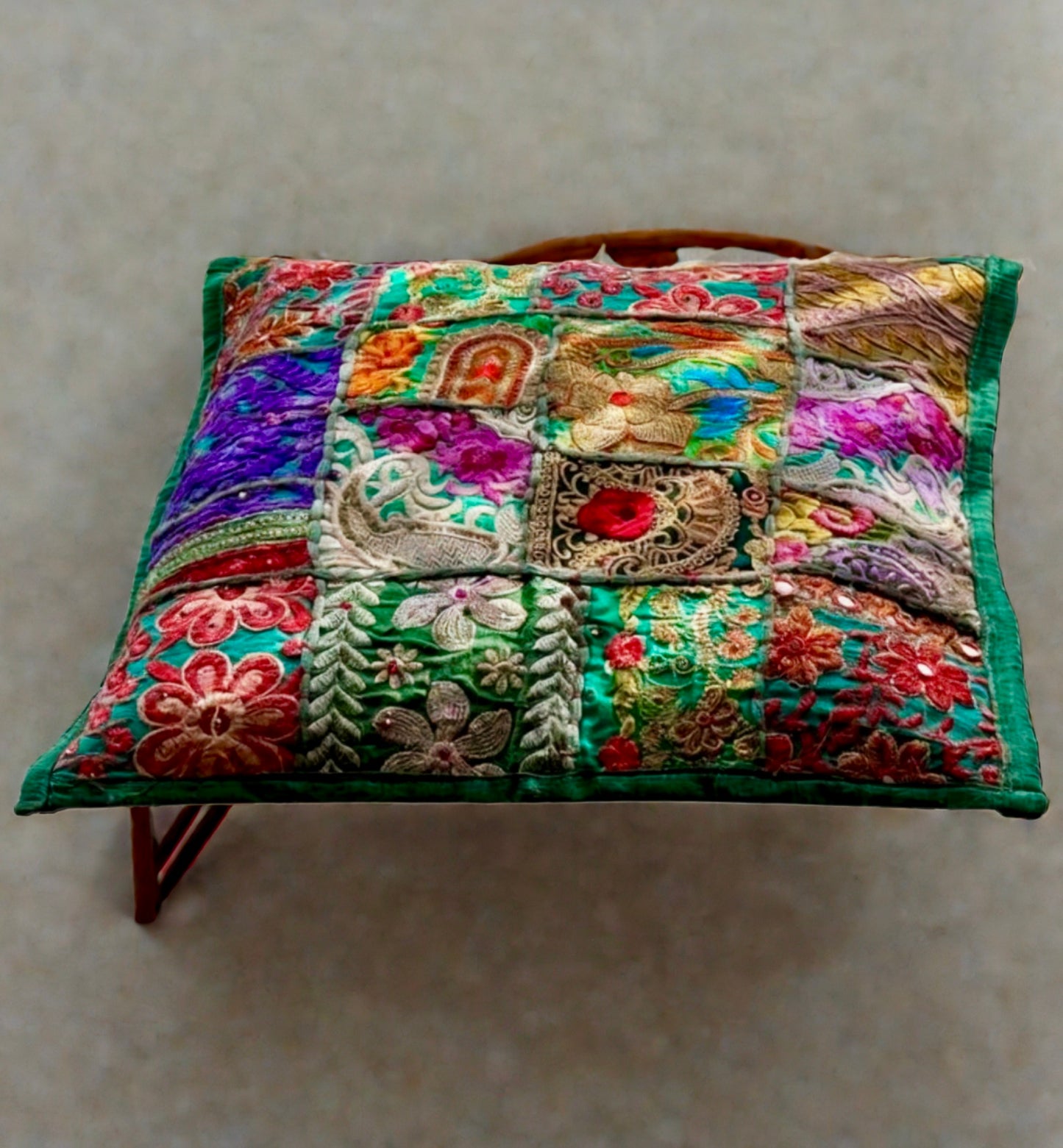 Cushion cover crafted from Khambhadia patchwork, showcasing a collage of vintage fabrics, intricate embroidery, and mirror accents in bold, vibrant colors.