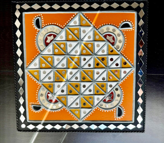 Decorative tile with geometric pattern on an orange background