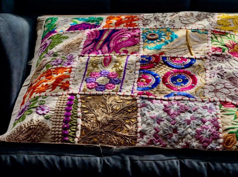 Cushion cover crafted from Khambhadia patchwork, showcasing a collage of vintage fabrics, intricate embroidery, and mirror accents in bold, vibrant colors.