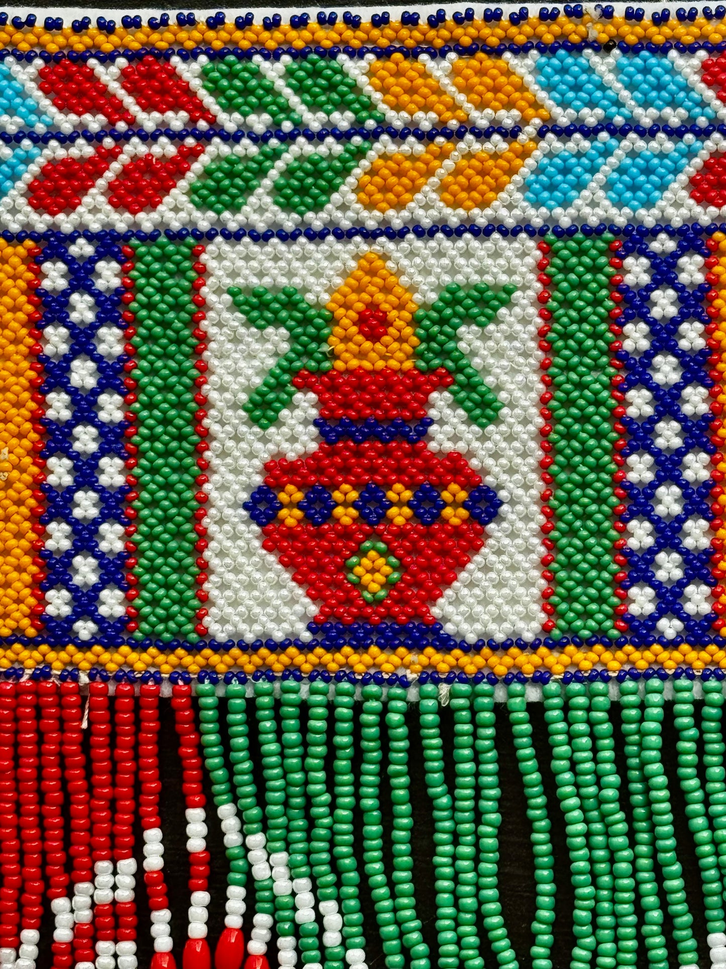 Close-up of a Motikaam pattern with geometric shapes and a central vase design.