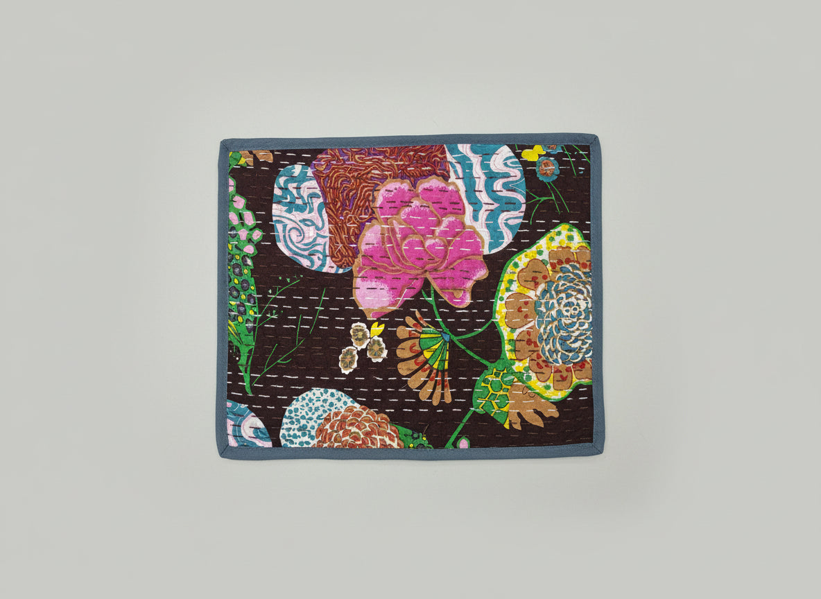Colorful floral Kantha work patterned placemat on a dark background