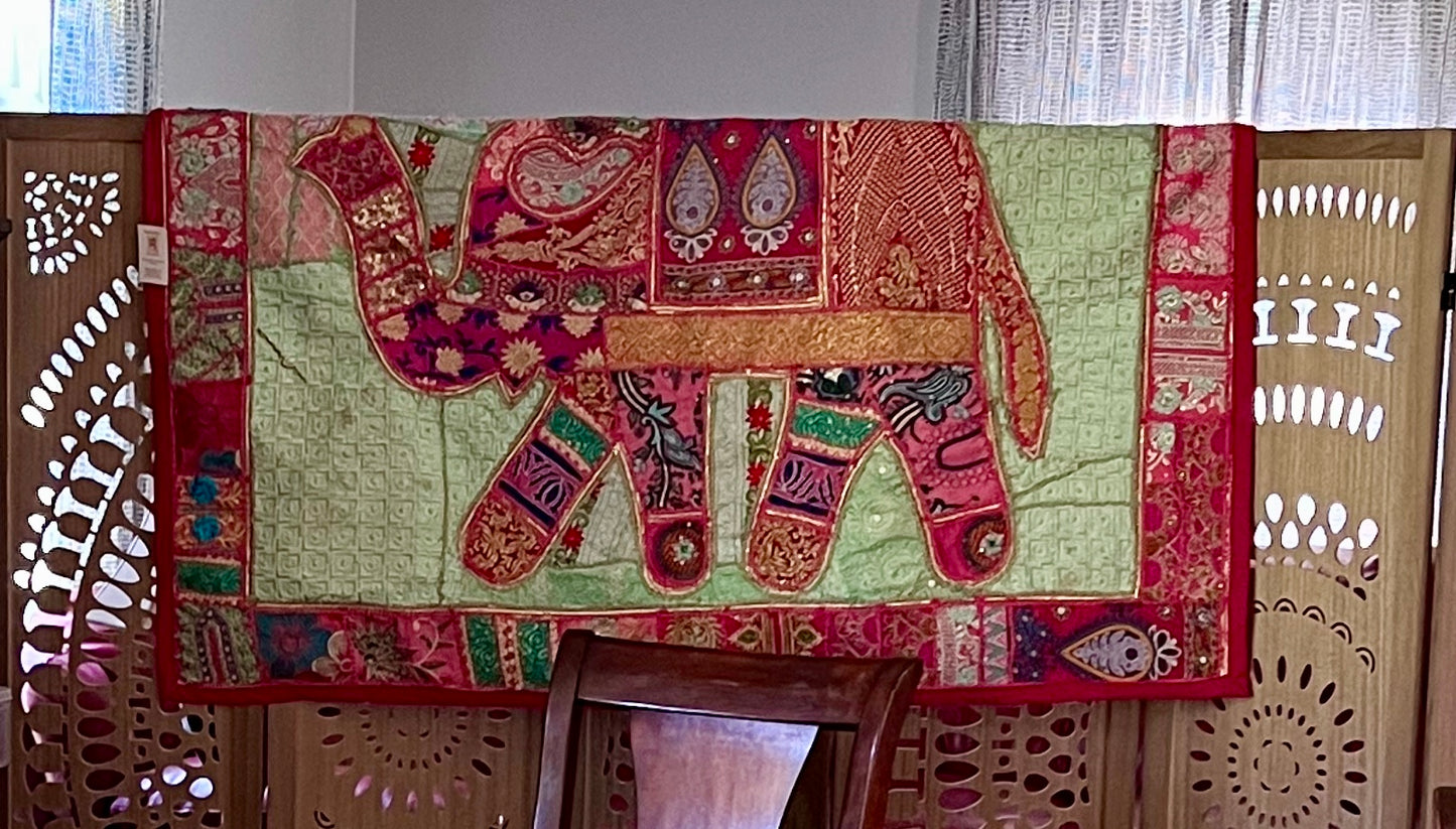 Decorative Khambhadia patchwork tapestry with an elephant design on a wooden stand.