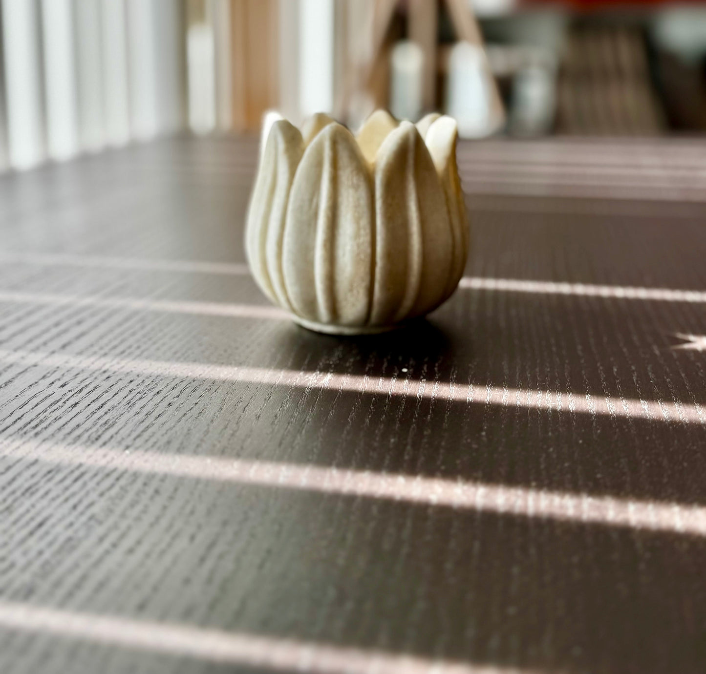 Decorative marble tea light holder on a textured surface with blurred background