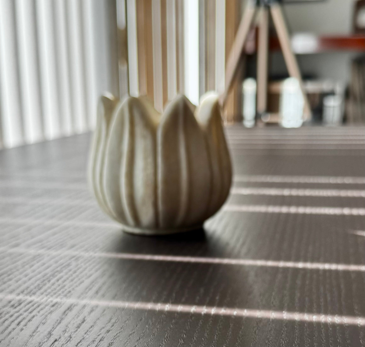 Decorative marble tea light holder on a textured surface with blurred background