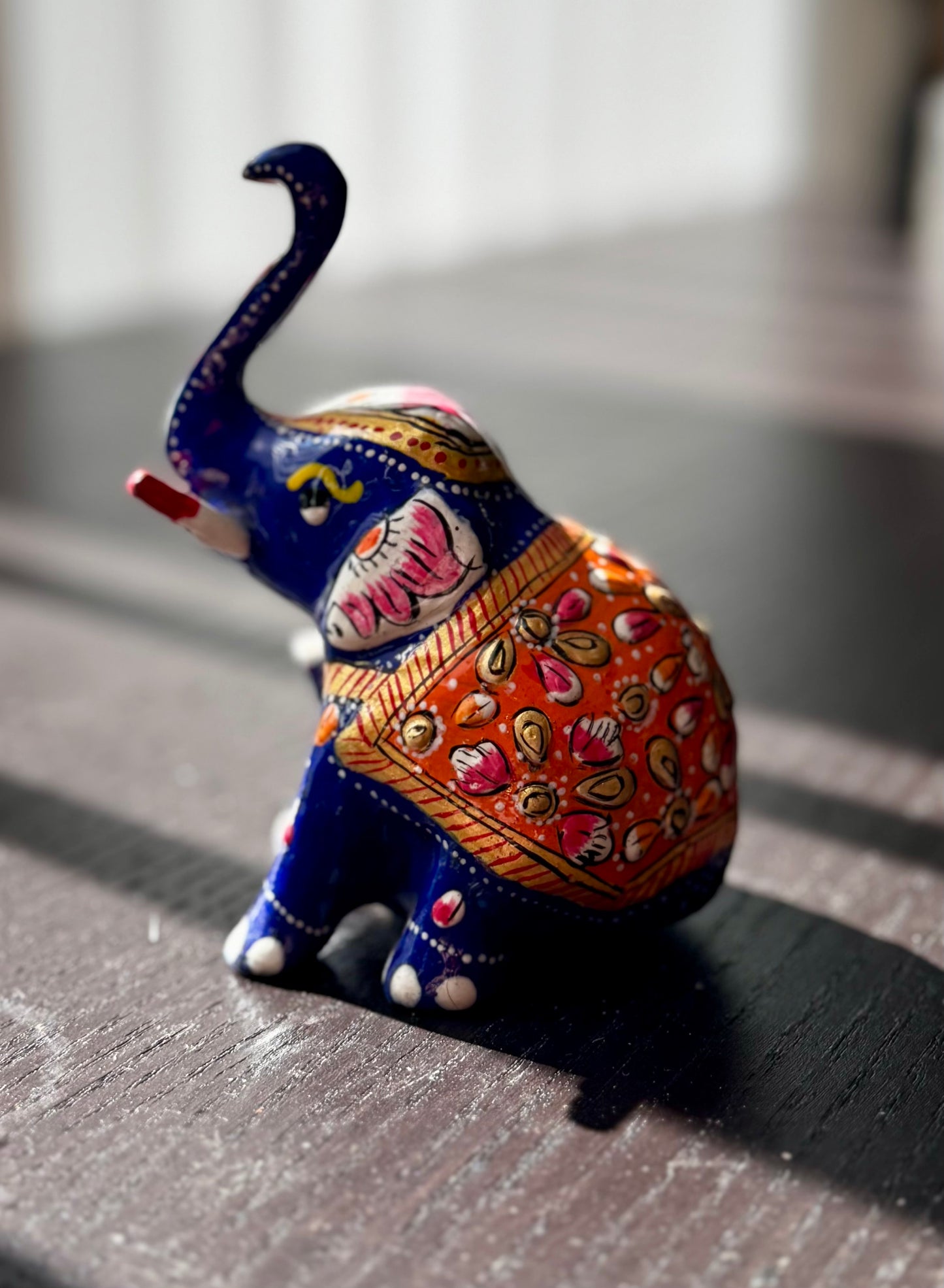 Decorative elephant figurine with colorful patterns on a dark surface