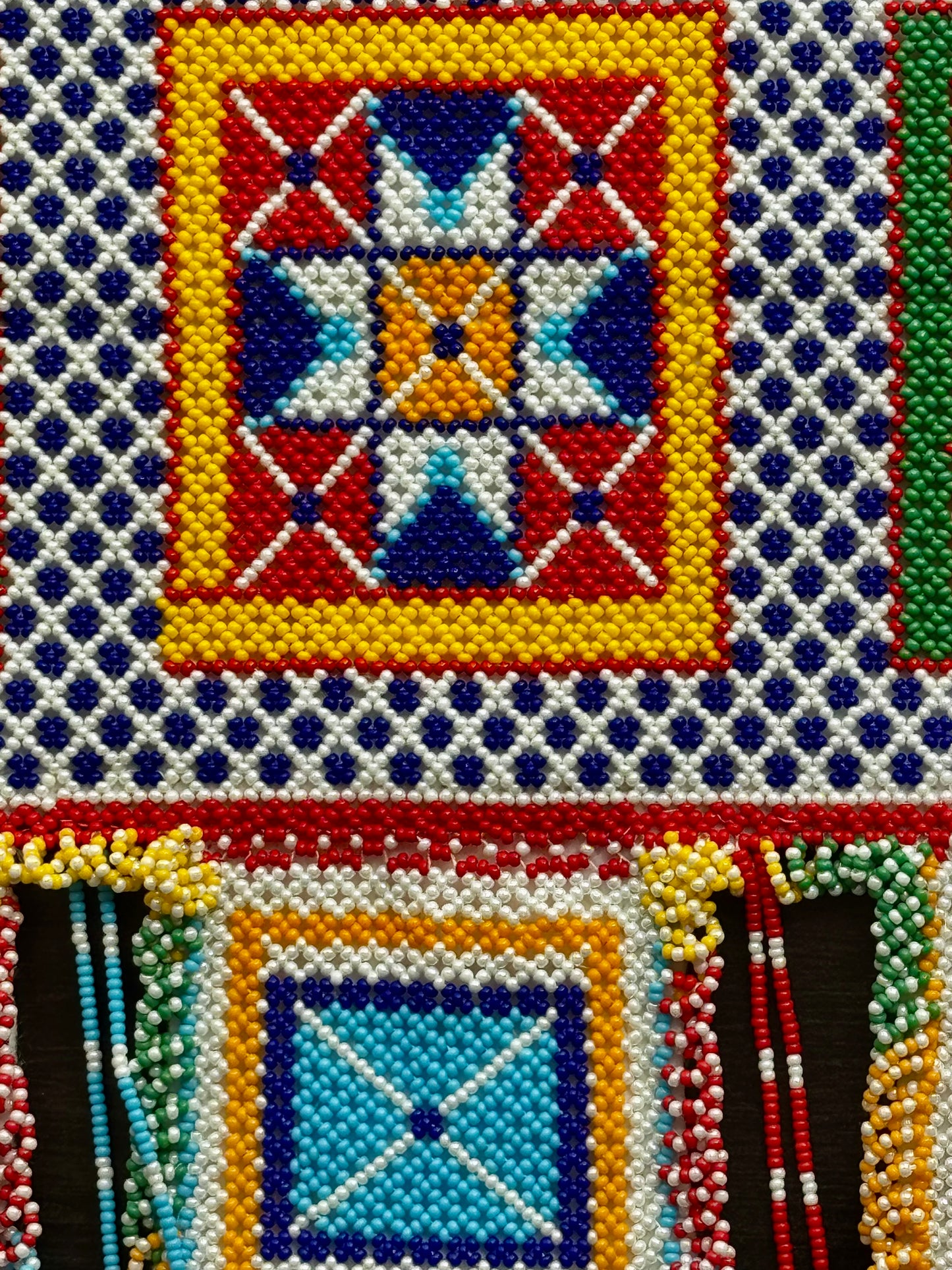 Close-up of a Motikaam design with geometric patterns and colorful beads.