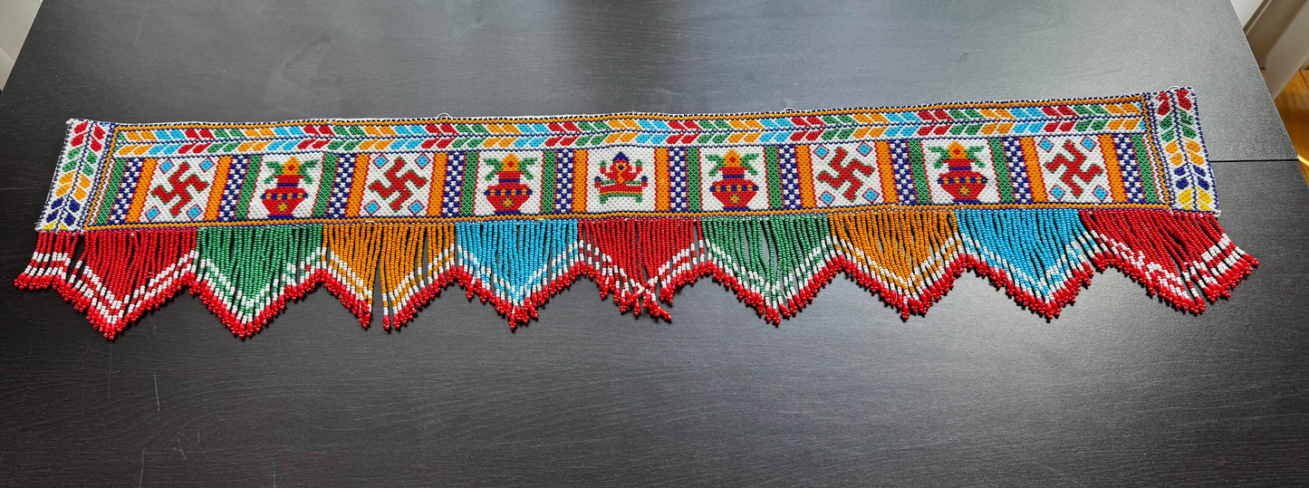 Decorative Motikaam valance with colorful patterns on a dark surface