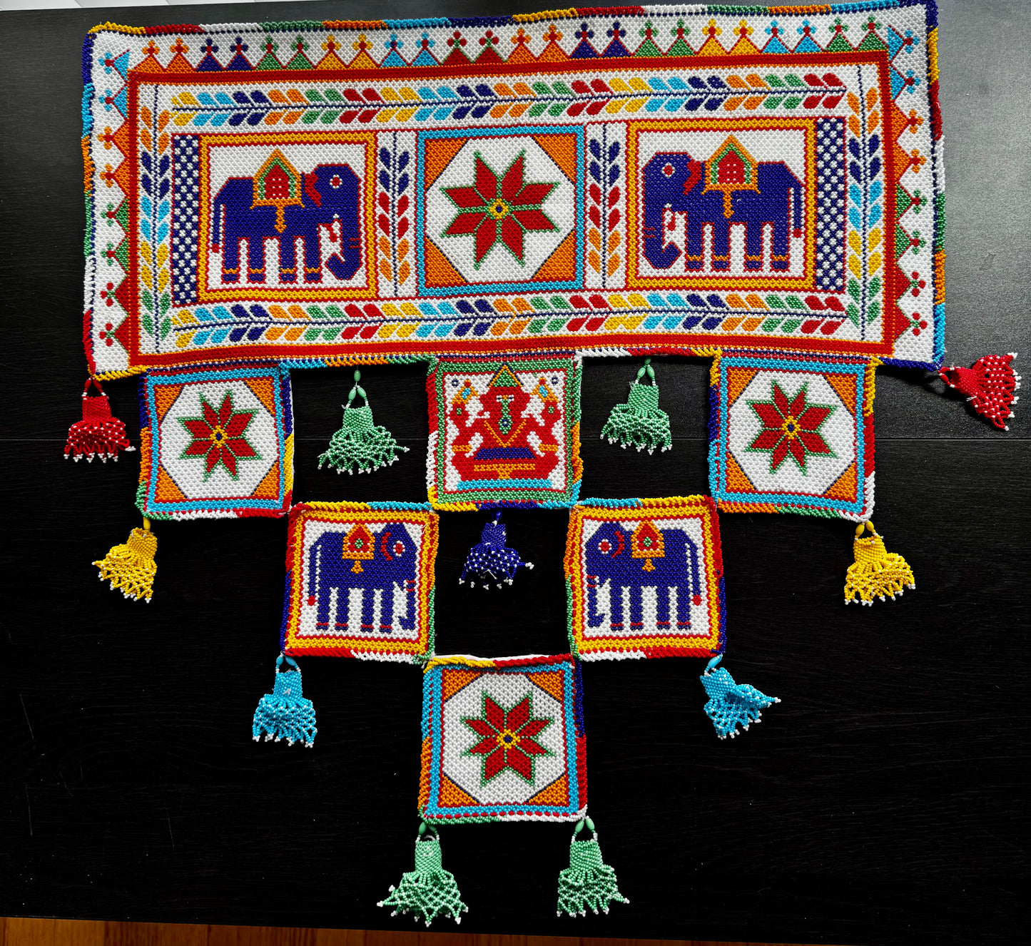 Colorful Motikaam with patterns and tassels on a black background
