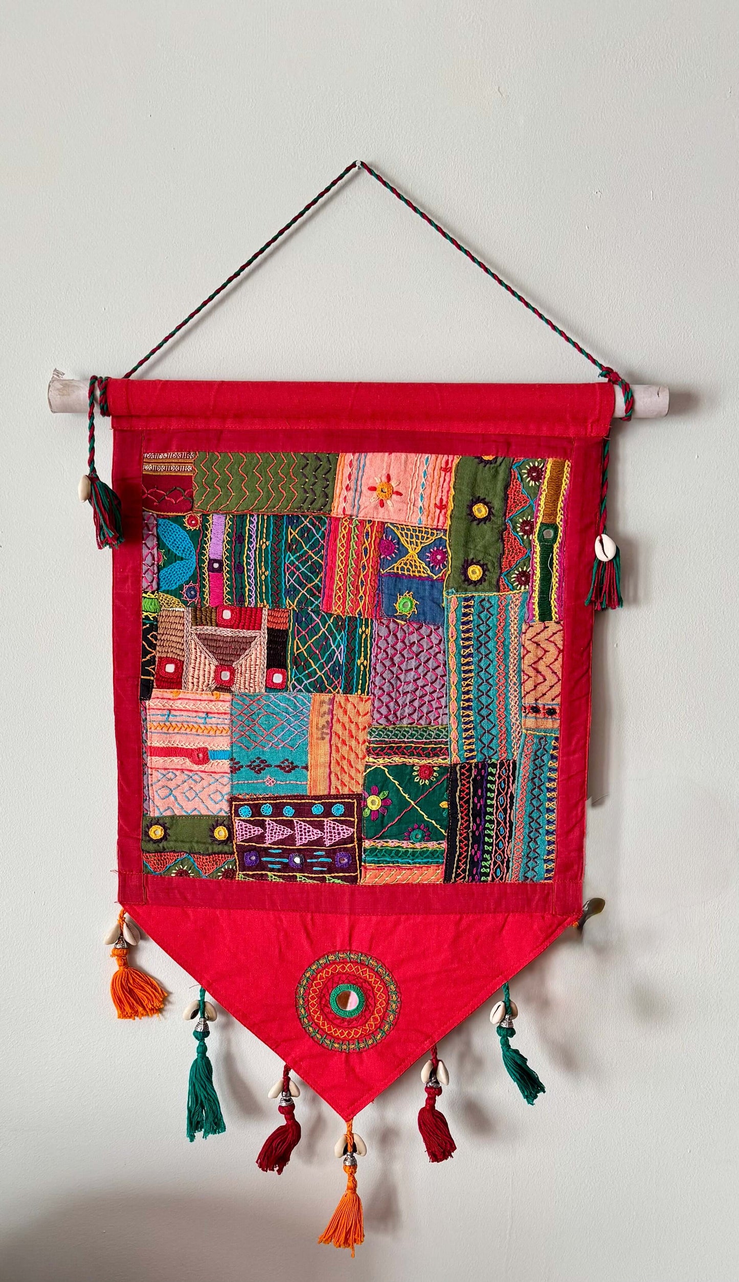 Handcrafted Lambani work textile wall decor, featuring intricate embroidery, mirror work, and vibrant patterns. A stunning display of traditional craftsmanship, adding cultural richness and texture to your space.