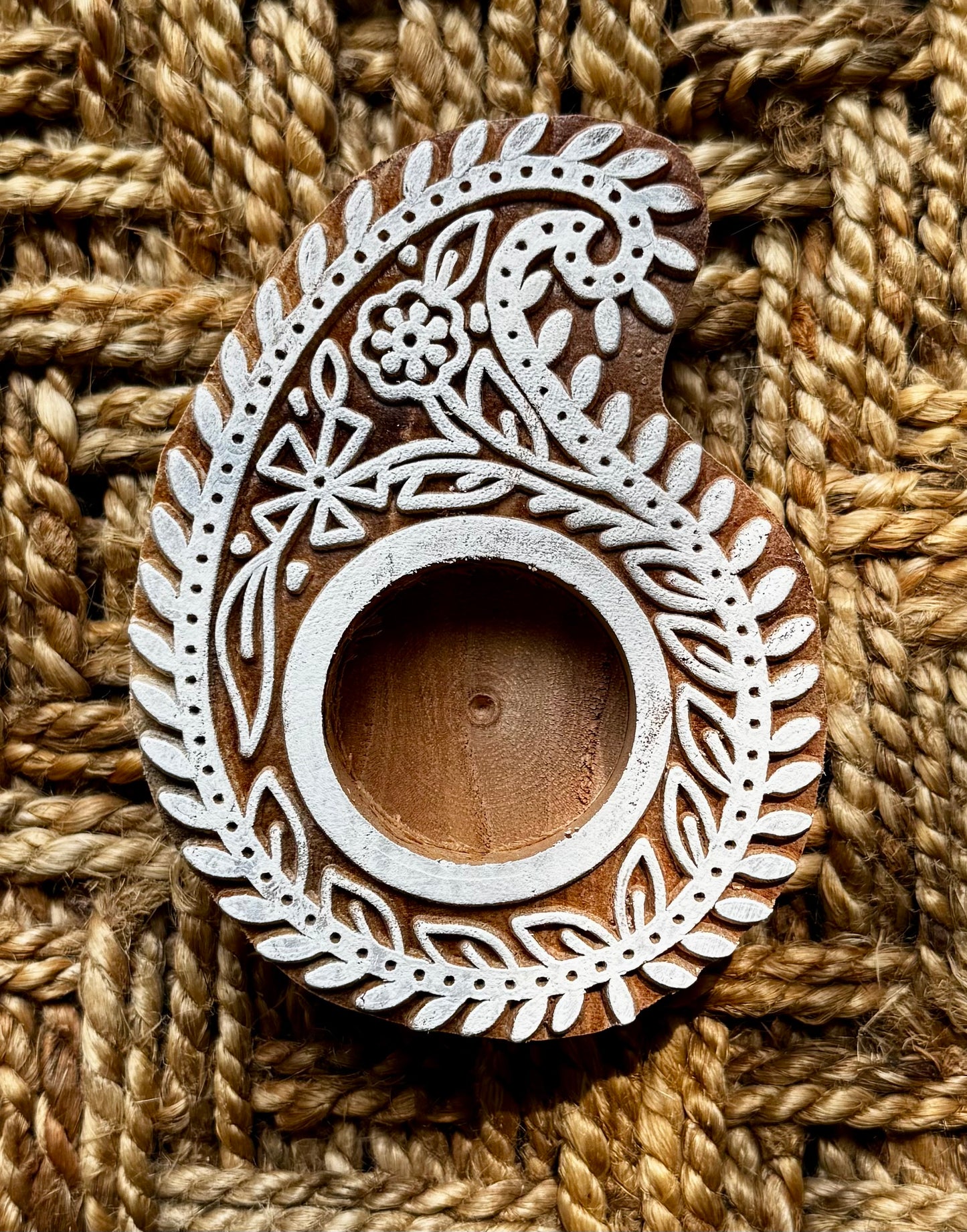 Hand engraved Wooden block tea light holder on a textured brown fabric background
