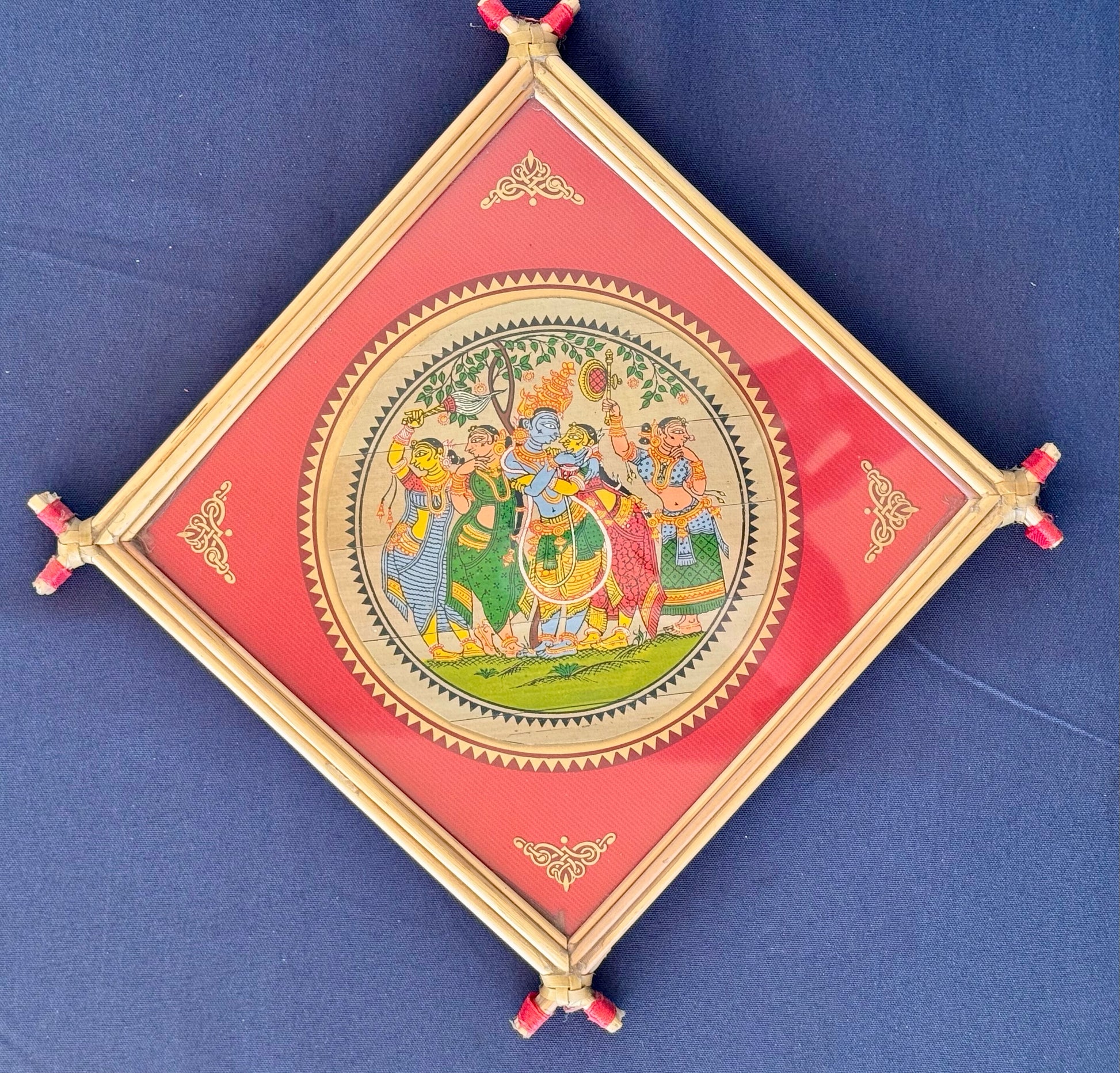 Hand-painted Pattachitra art featuring traditional motifs and mythological stories, elegantly framed with unique bamboo detailing.