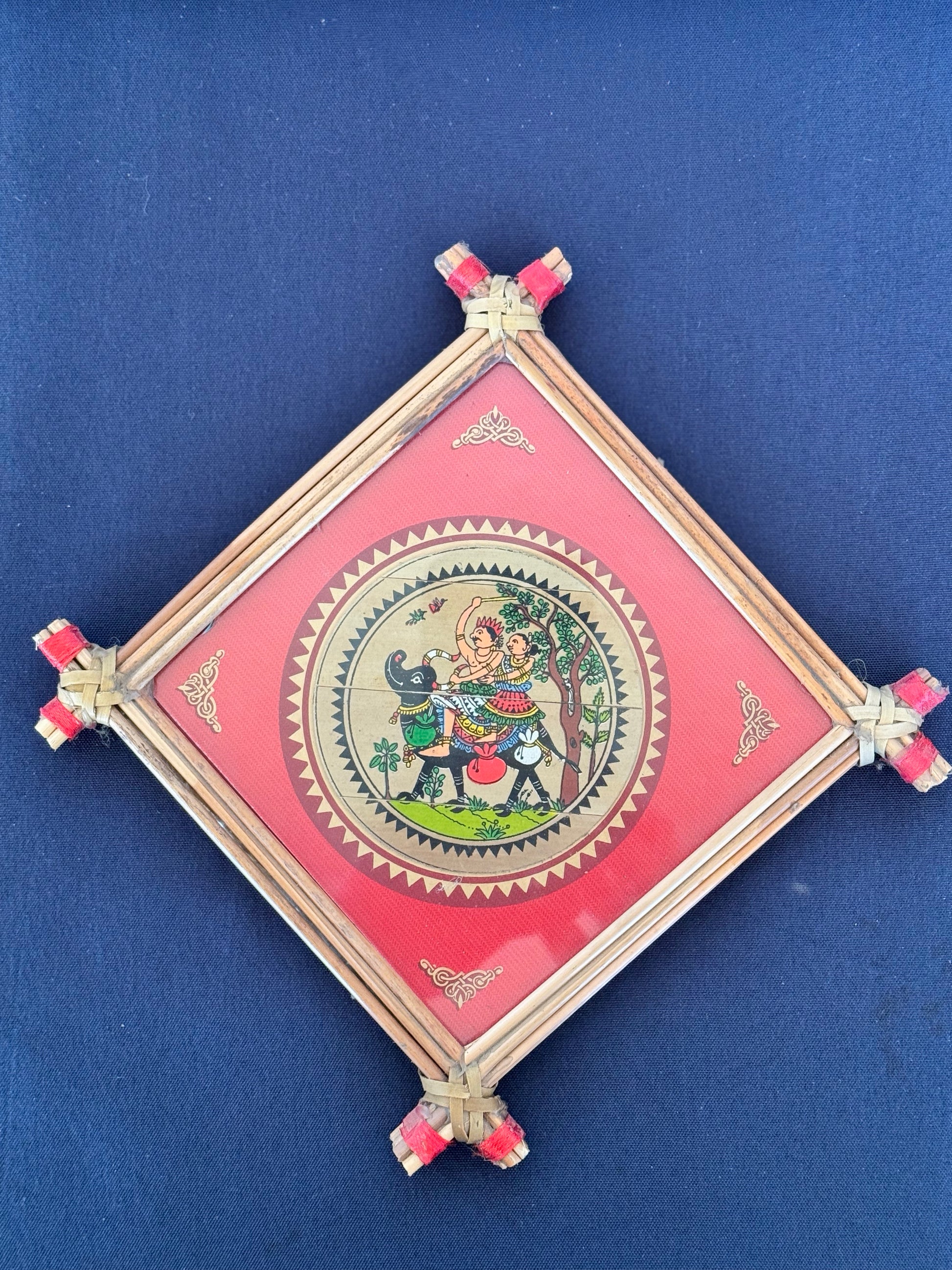 Hand-painted Pattachitra art featuring traditional motifs and mythological stories, elegantly framed with unique bamboo detailing.