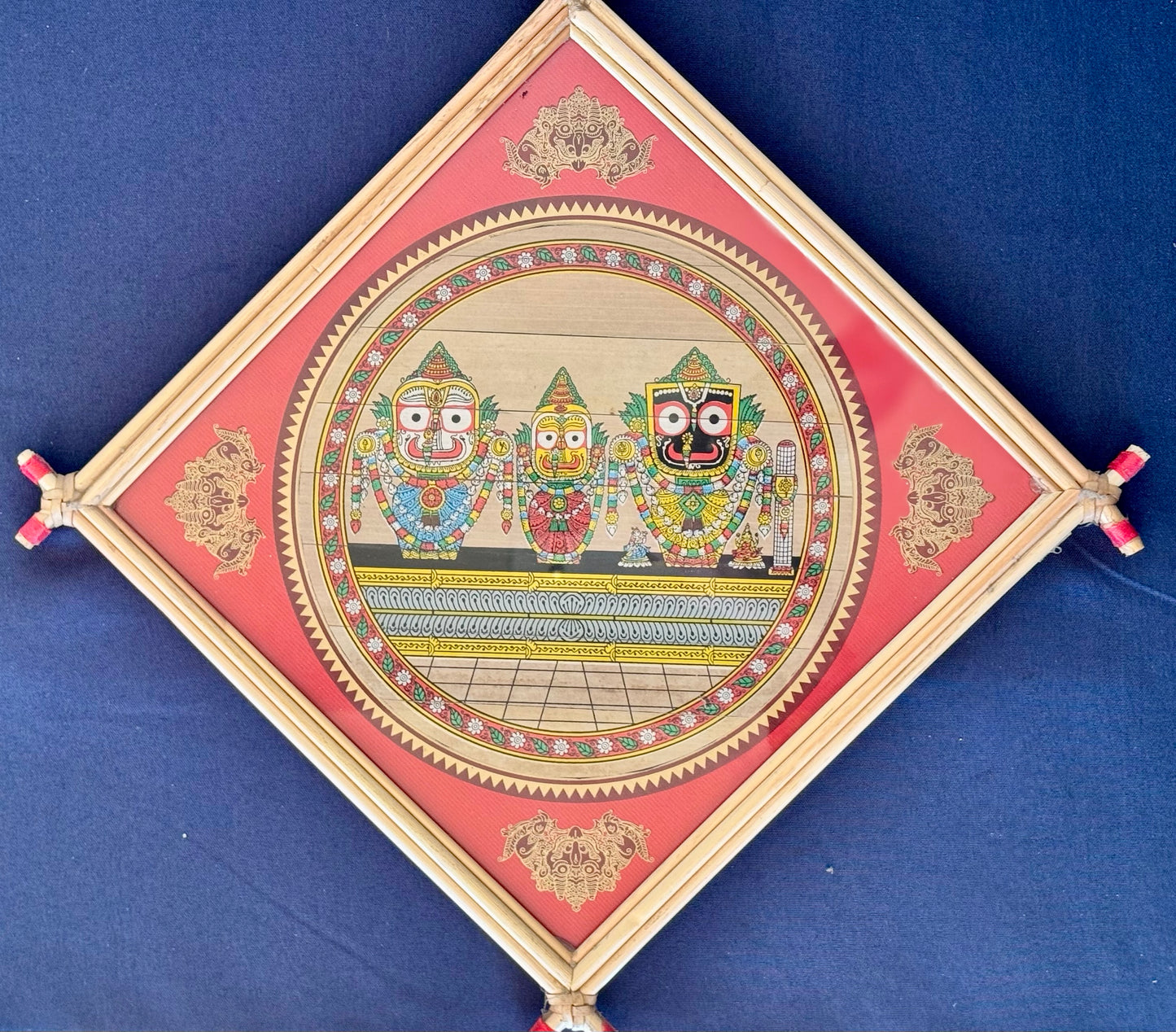 Hand-painted Pattachitra art featuring traditional motifs and mythological stories, elegantly framed with unique bamboo detailing.
