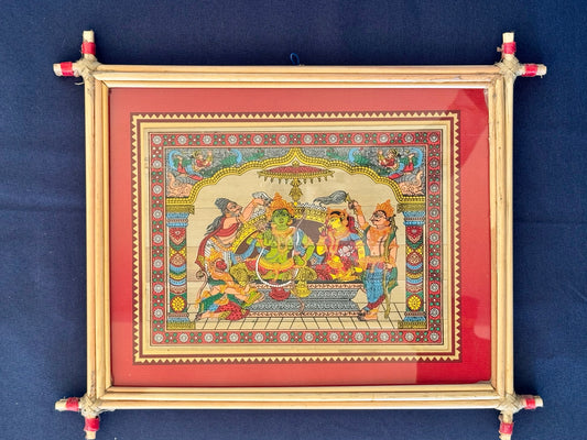 Hand-painted Pattachitra art featuring traditional motifs and mythological stories, elegantly framed with unique bamboo detailing.