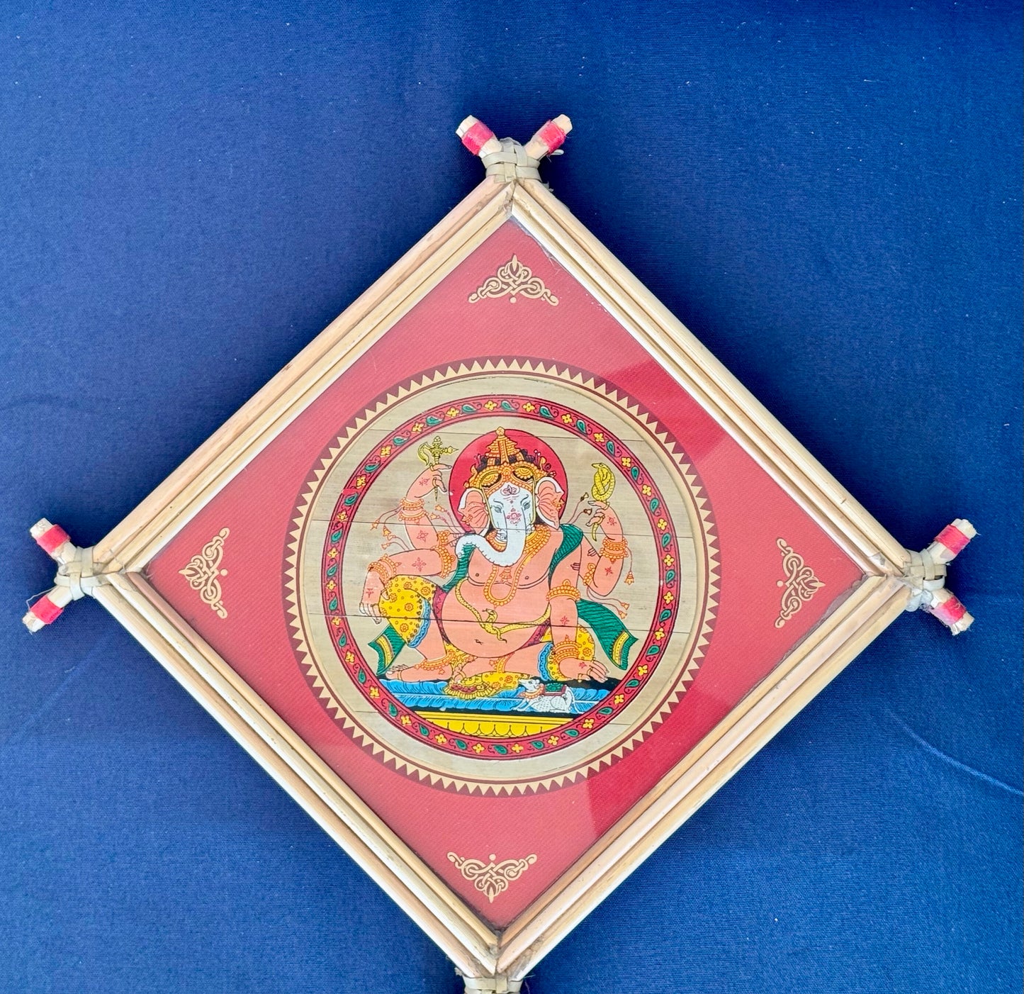 Hand-painted Pattachitra art featuring traditional motifs and mythological stories, elegantly framed with unique bamboo detailing.