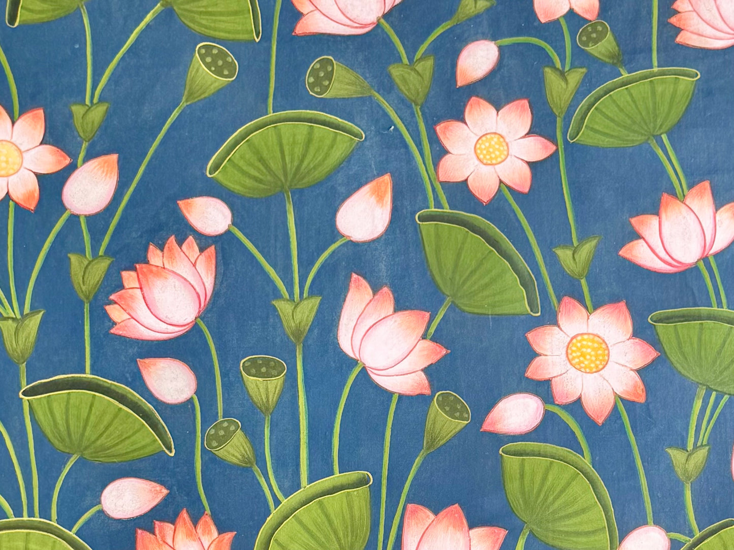 Close up Pattern of pink flowers and green leaves on a blue background hand painted in Pichwai Art style.