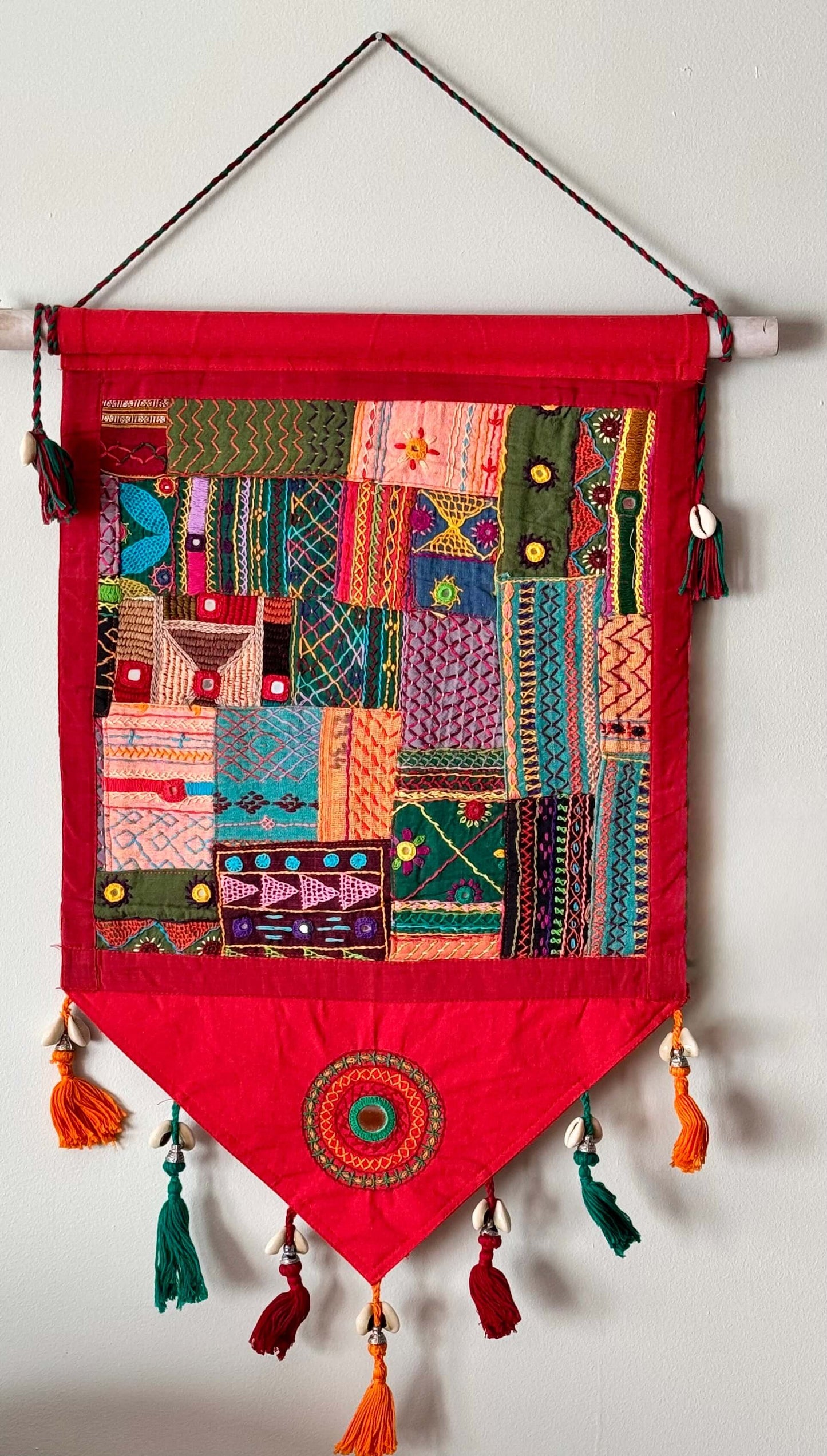Handcrafted Lambani work textile wall decor, featuring intricate embroidery, mirror work, and vibrant patterns. A stunning display of traditional craftsmanship, adding cultural richness and texture to your space.