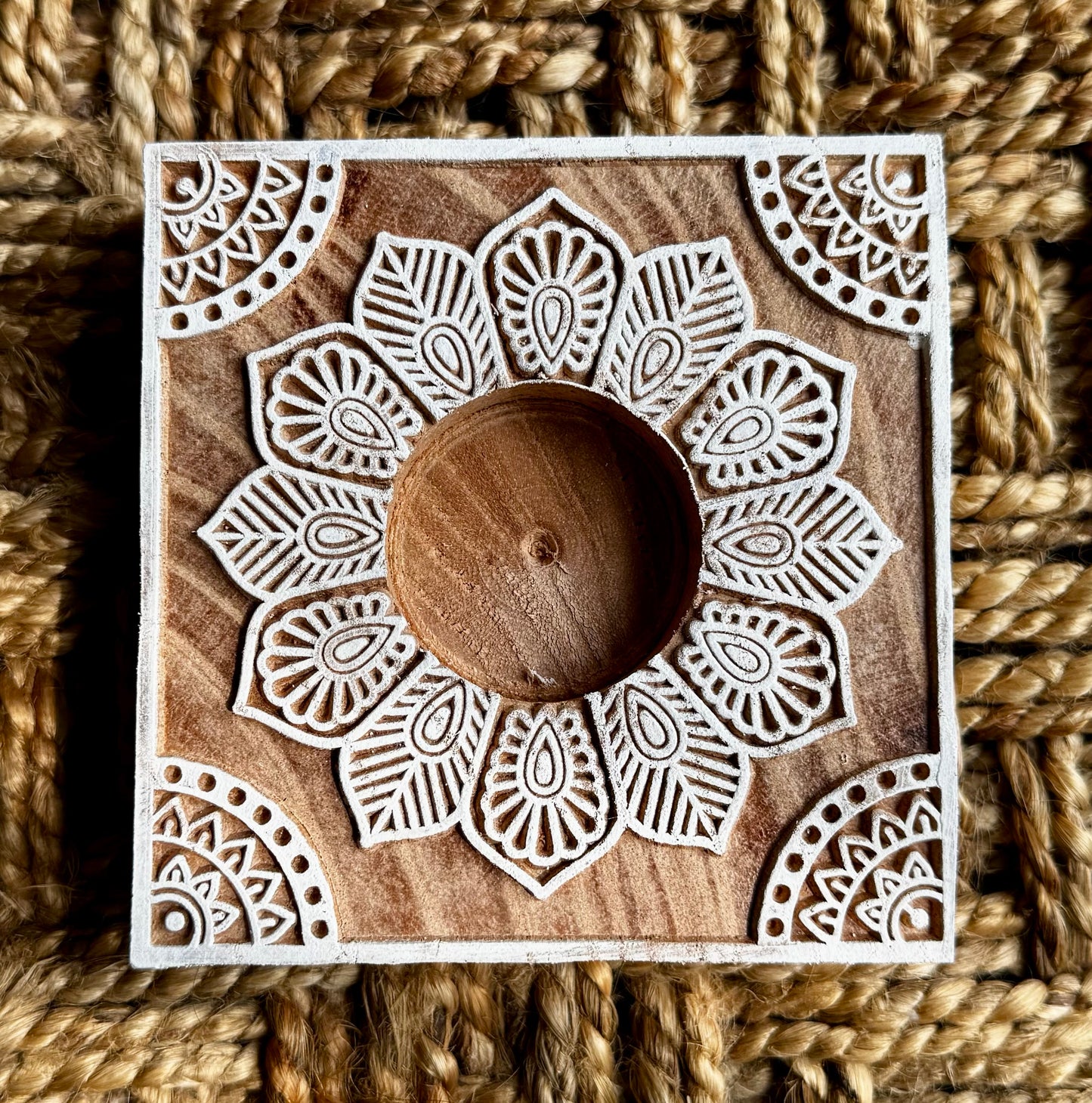 Hand engraved Wooden block tea light holder with intricate lace pattern on a textured brown background