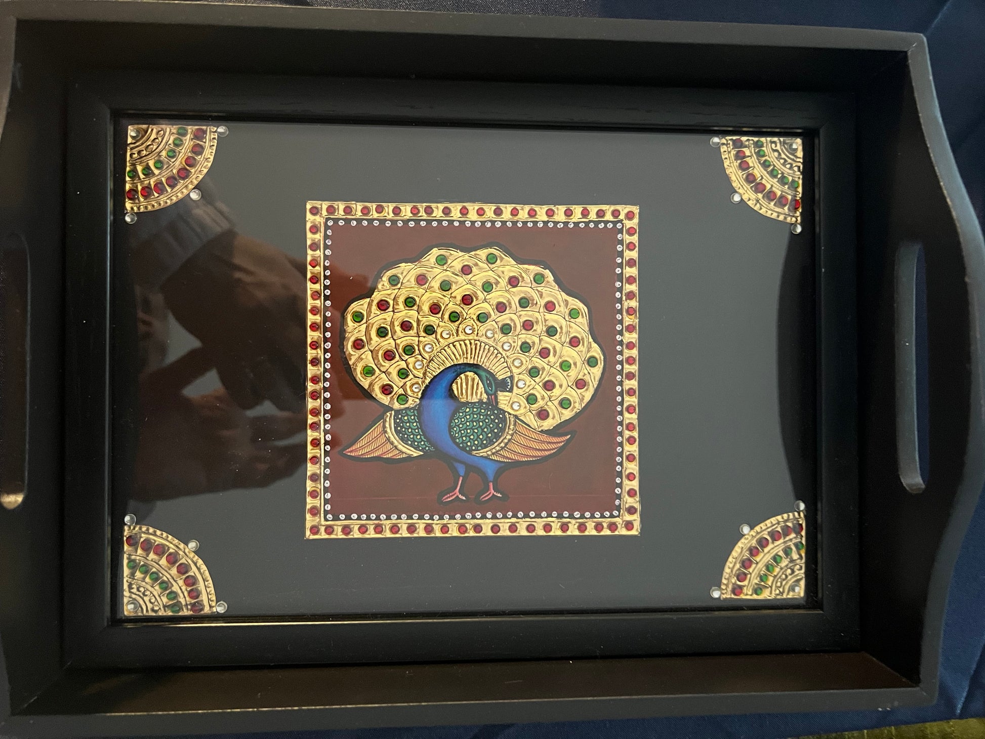 Handcrafted Tanjore work wooden tray featuring intricate gold leaf detailing and vibrant colors, showcasing traditional Indian artistry.