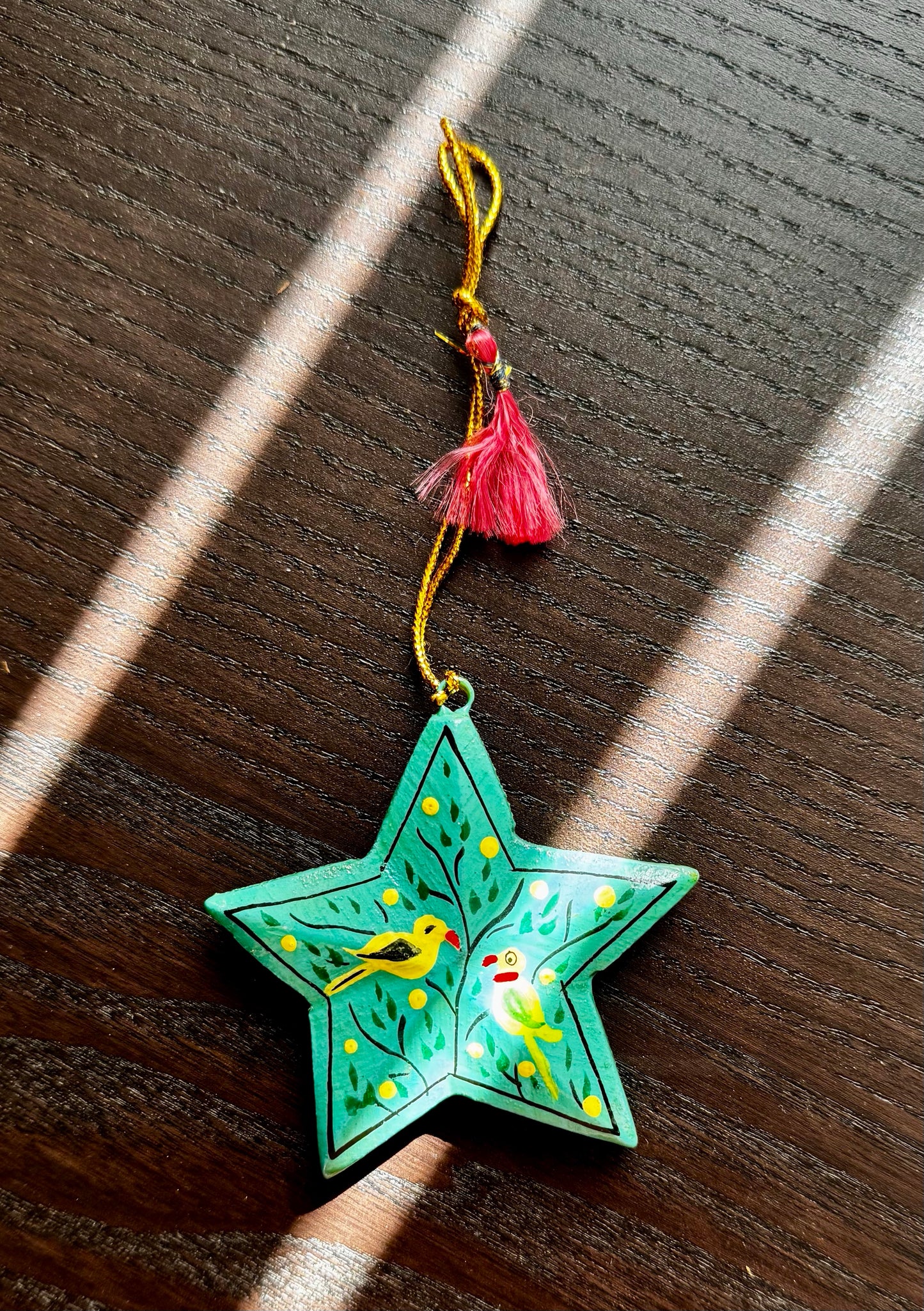 Decorative star-shaped ornament with birds on a wooden surface