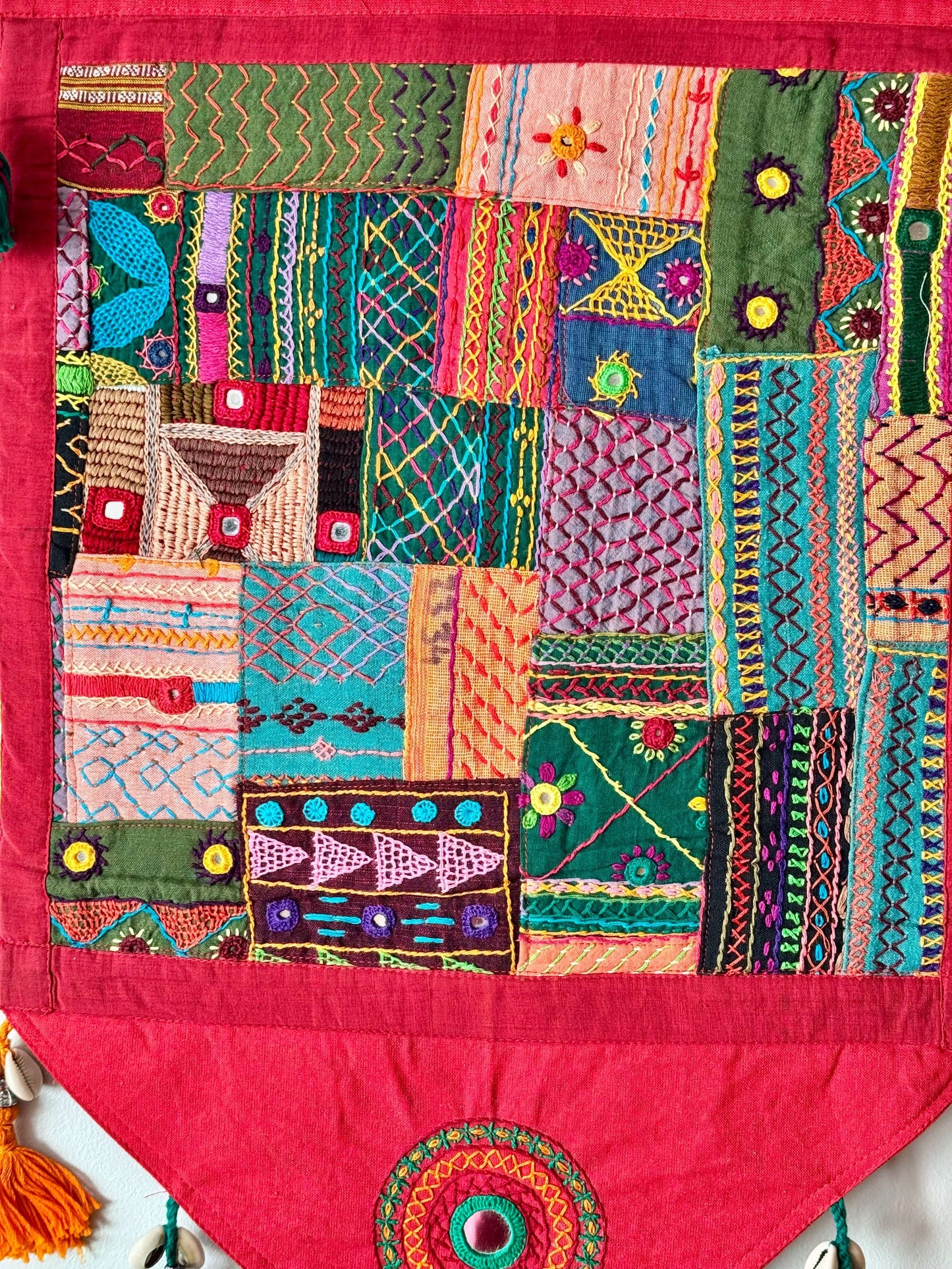 Handcrafted Lambani work textile wall decor, featuring intricate embroidery, mirror work, and vibrant patterns. A stunning display of traditional craftsmanship, adding cultural richness and texture to your space.