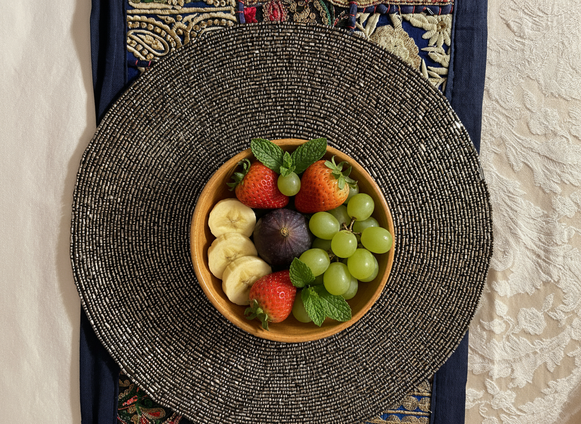 Fruit bowl with strawberries, grapes, and bananas on a textured plate.