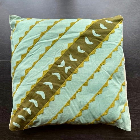 Decorative pillow with geometric pattern on a dark surface