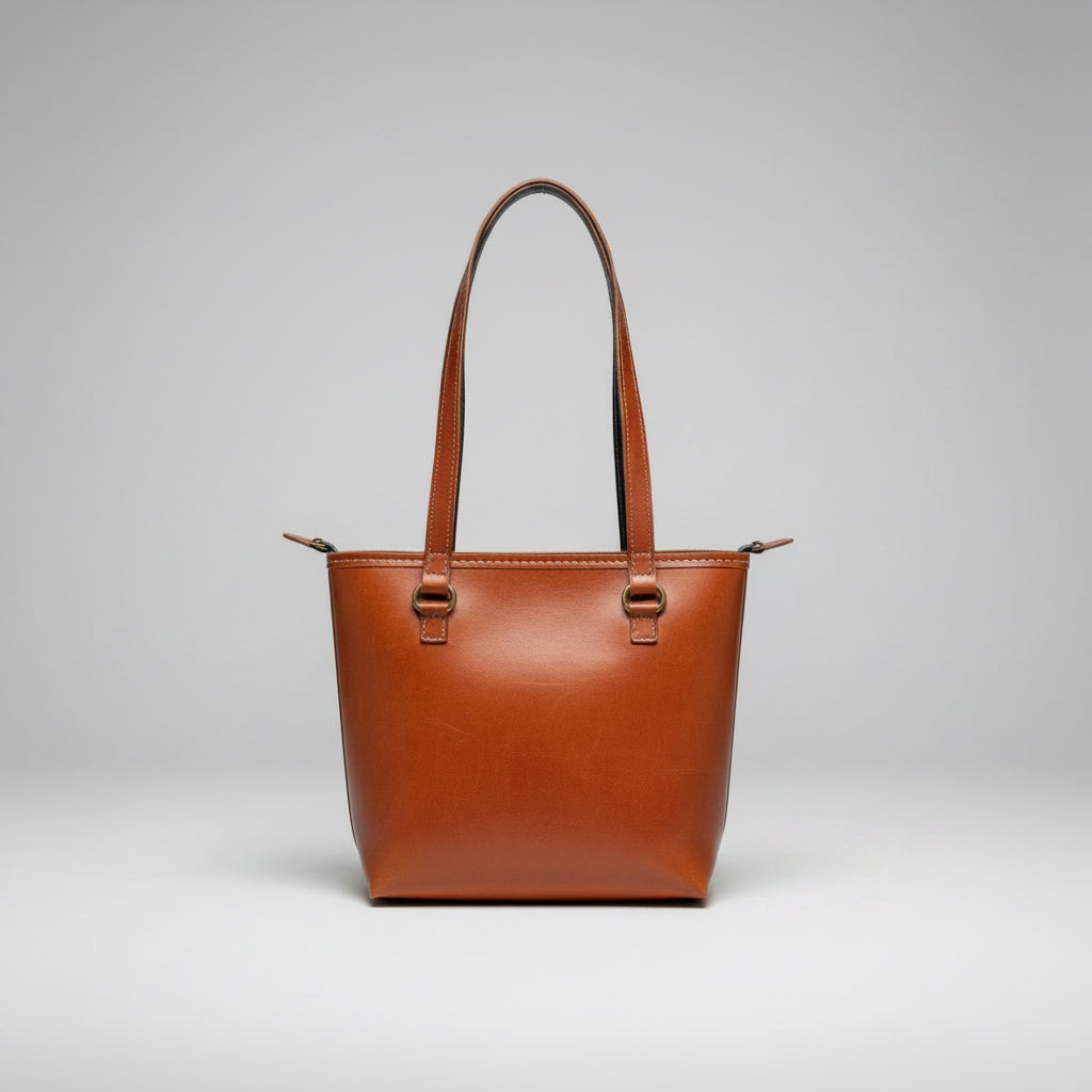 Brown leather Kutchi tote bag on a wooden surface with a white radiator in the background