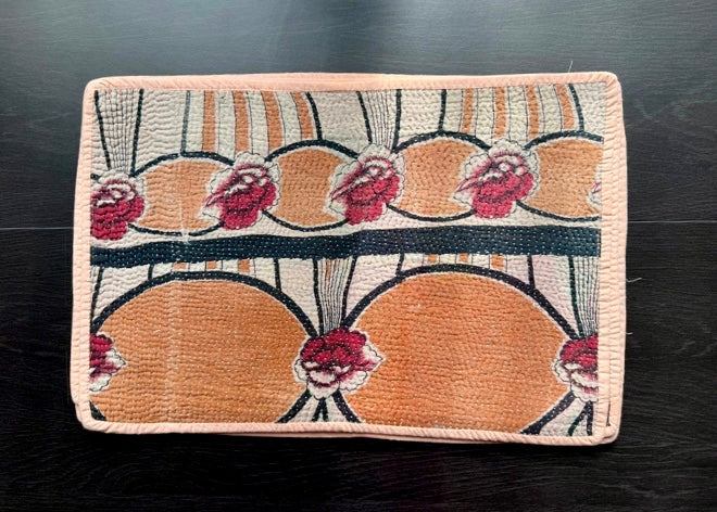 Decorative woven mat with a floral pattern on a dark surface