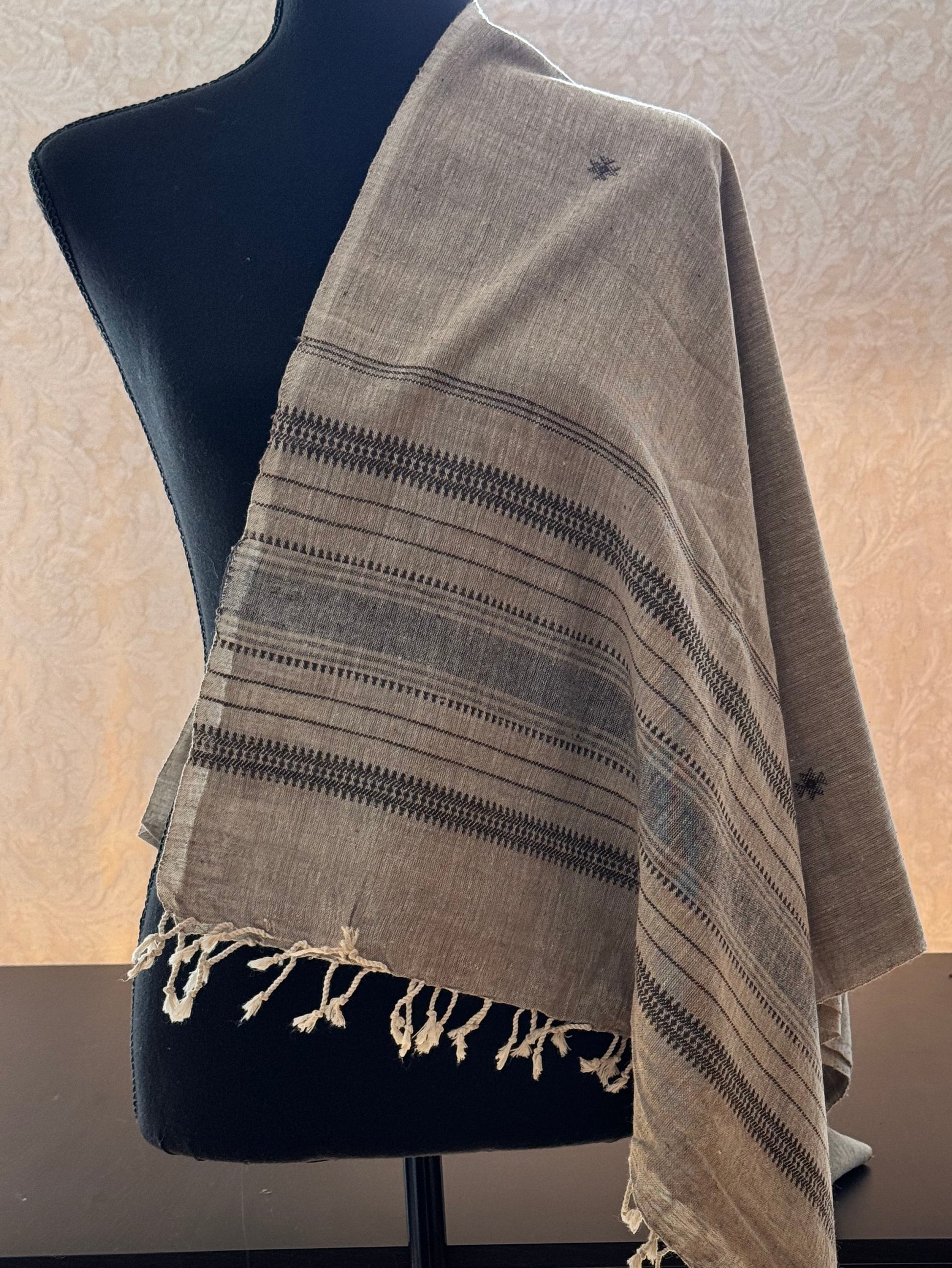 Textured cotton handwoven stole draped over a chair with a neutral background
