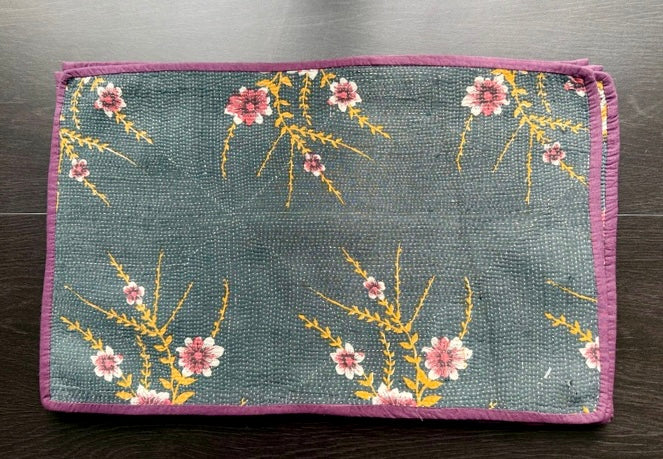 Floral patterned Kantha work placemats on a wooden surface