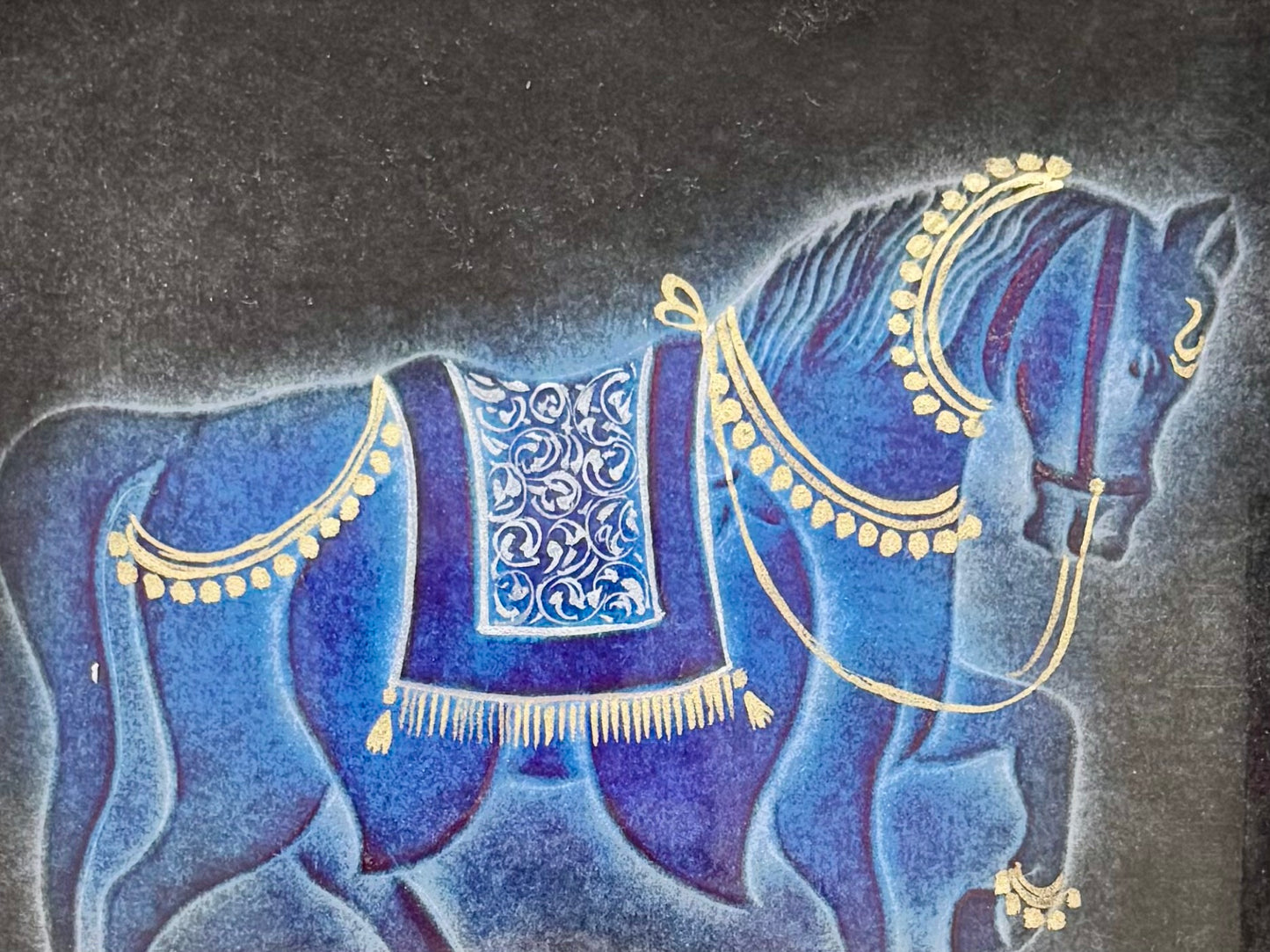 Decorative illustration of a blue horse nail drawn artwork with gold details on a dark background