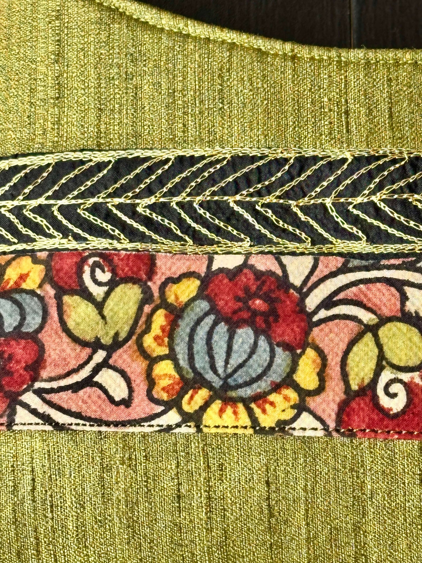 Close-up of a floral embroidery on a green fabric background