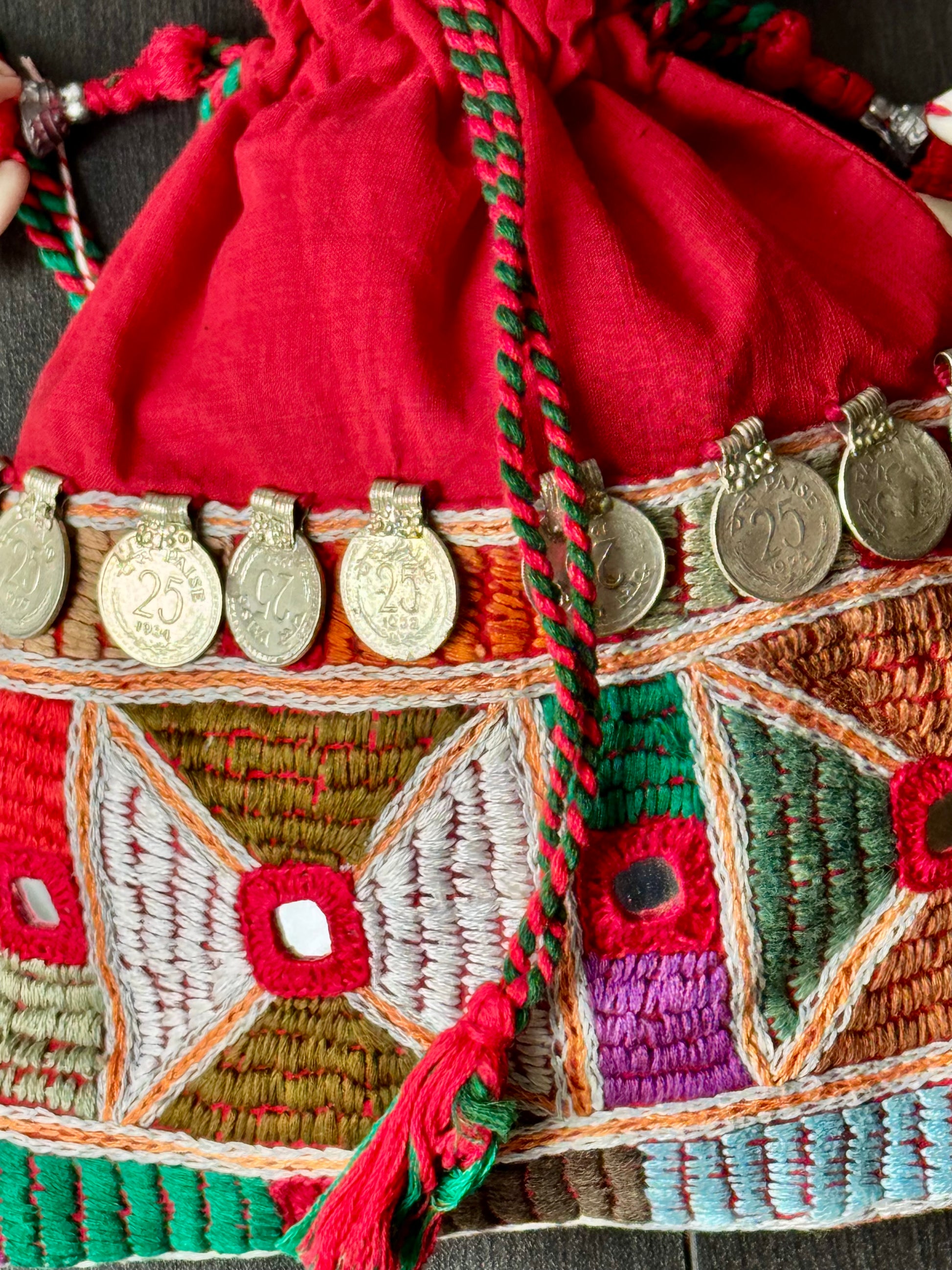 Red potli bag with intricate Lambani embroidery work