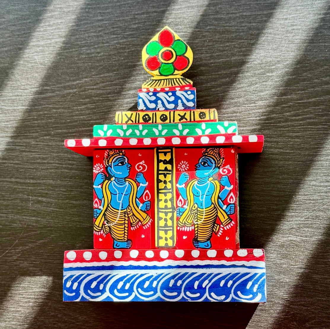 Colorful miniature temple model on a wooden surface