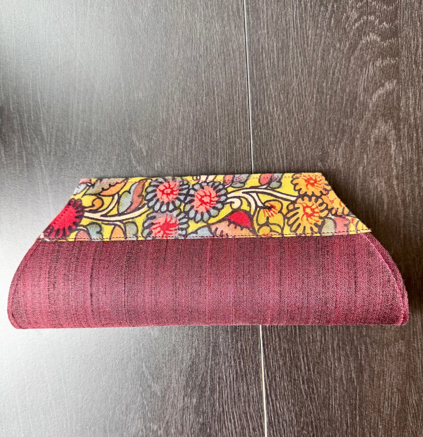 A collection of hand-painted kalamkari clutch purses in various colors, featuring intricate patterns.