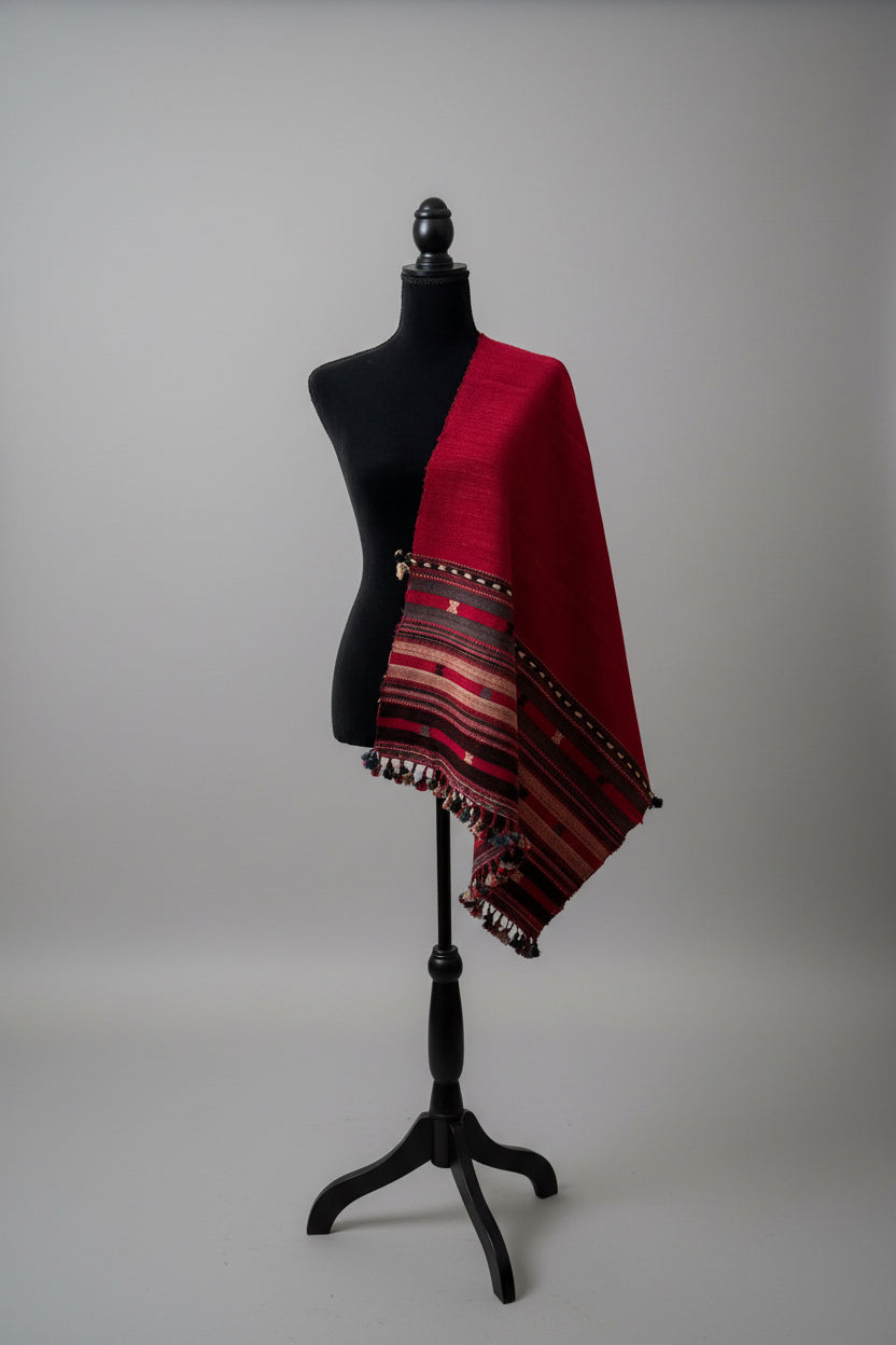 Red and black patterned raw silk scarf draped over a mannequin on a gray background