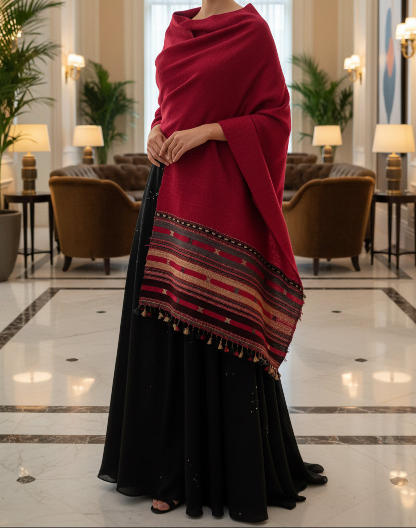 Person wearing a red raw silk stole  over a black dress in a hotel lobby.