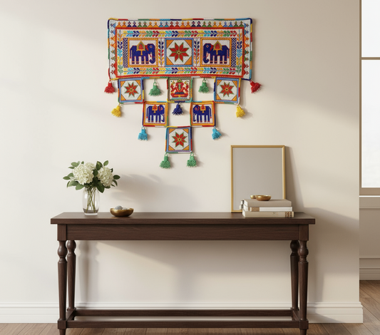 Decorative wall hanging with colorful patterns above a wooden console table.
