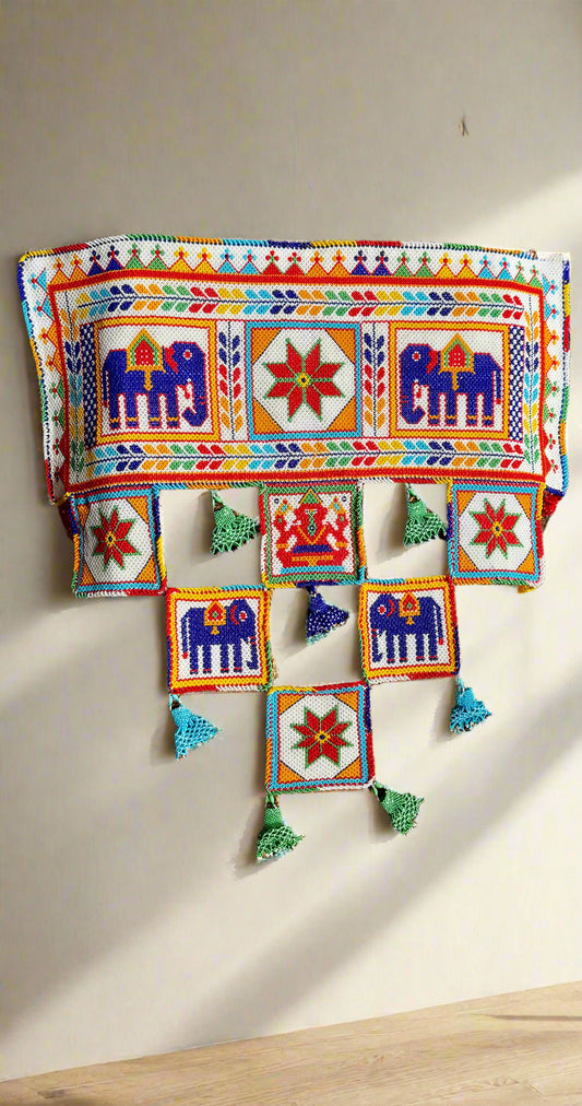 Decorative Motikaam - strung Pearl work Ganesha wall hanging with colorful design on a textured fabric background