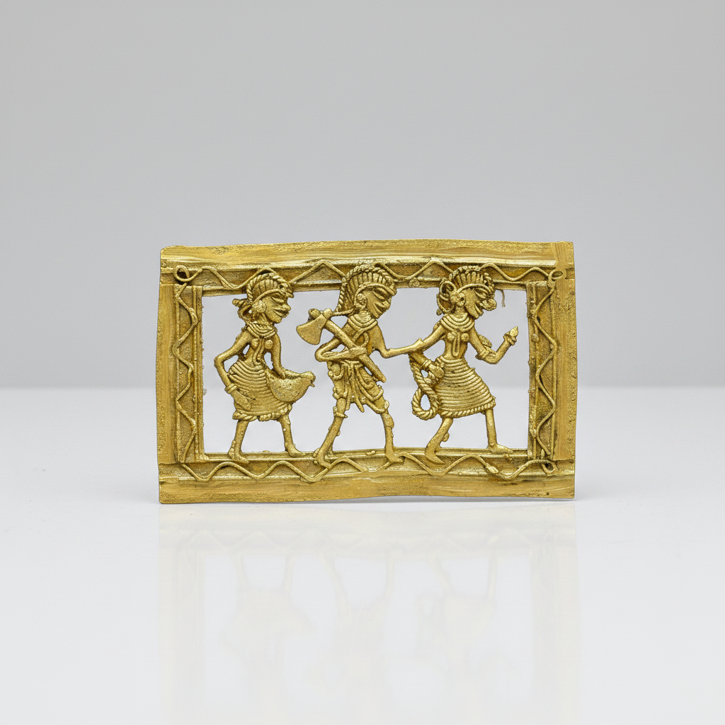 A rectangular brass Dhokra piece featuring three stylized dancing figures with a decorative border, photographed on a clean light gray studio background.