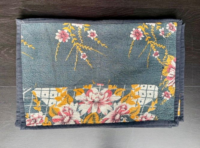 Floral patterned Kantha work placemats on a wooden surface
